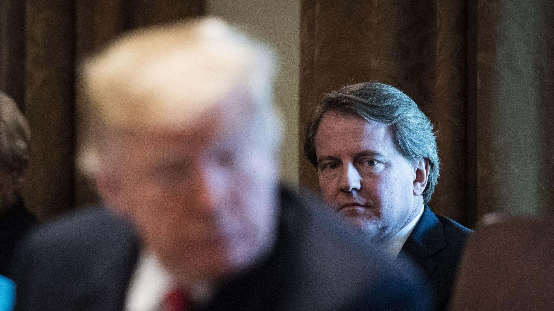 Don McGahn, the former White House lawyer, sitting behind Trump in a photograph