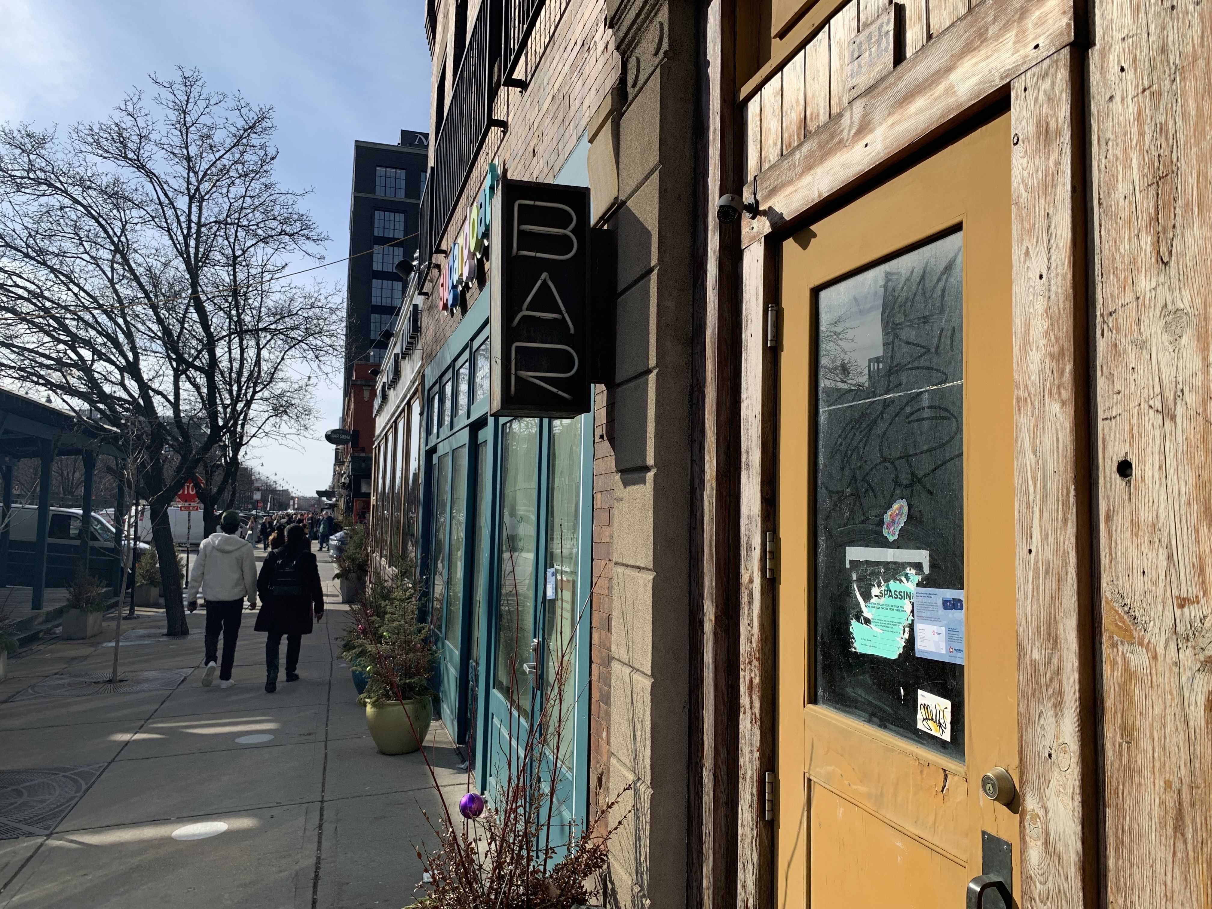 Photo of a door with stickers and boarded up windows