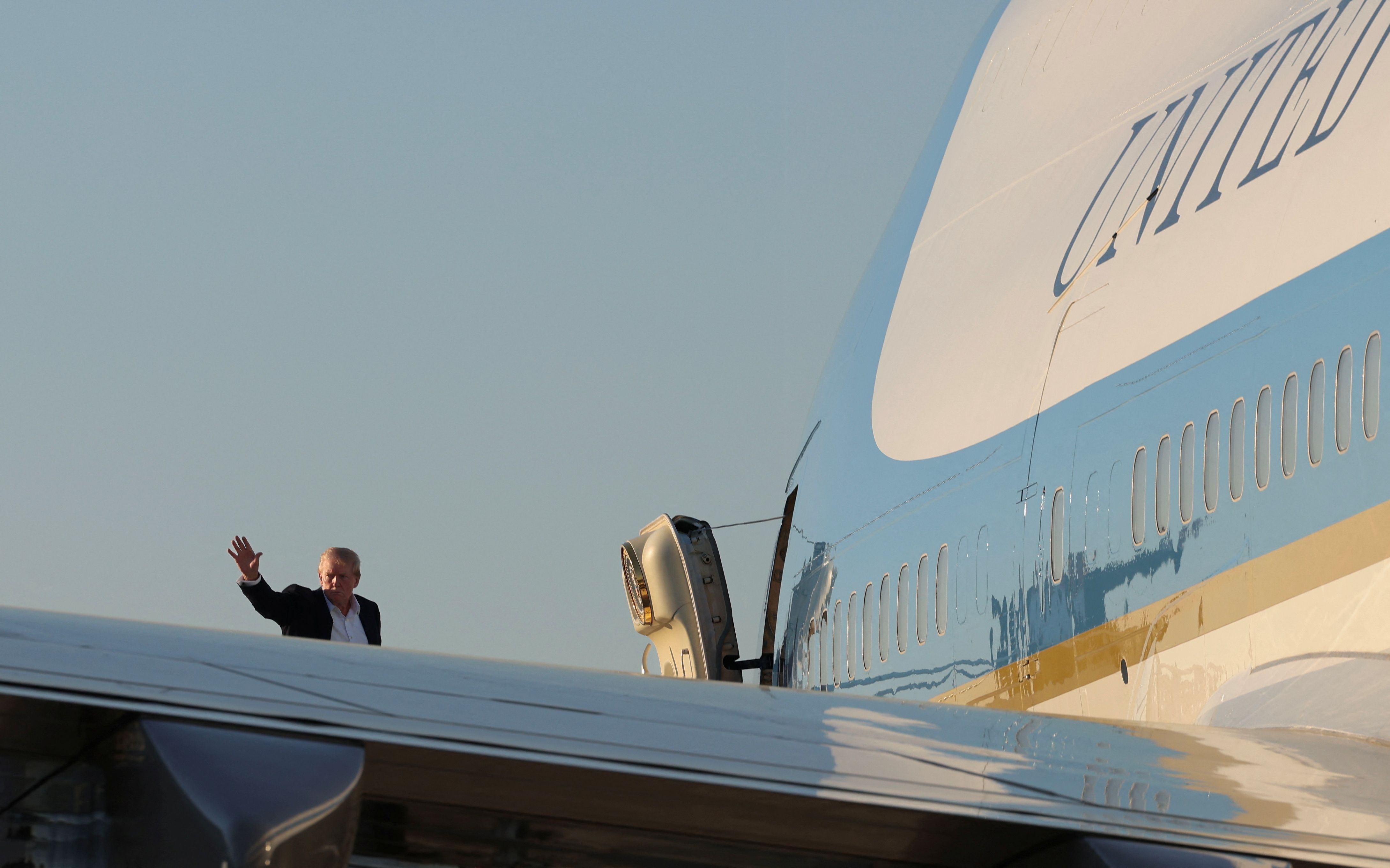 President Trump waves as he boards Air Force One in West Palm Beach, Fla., to return to Washington yesterday.