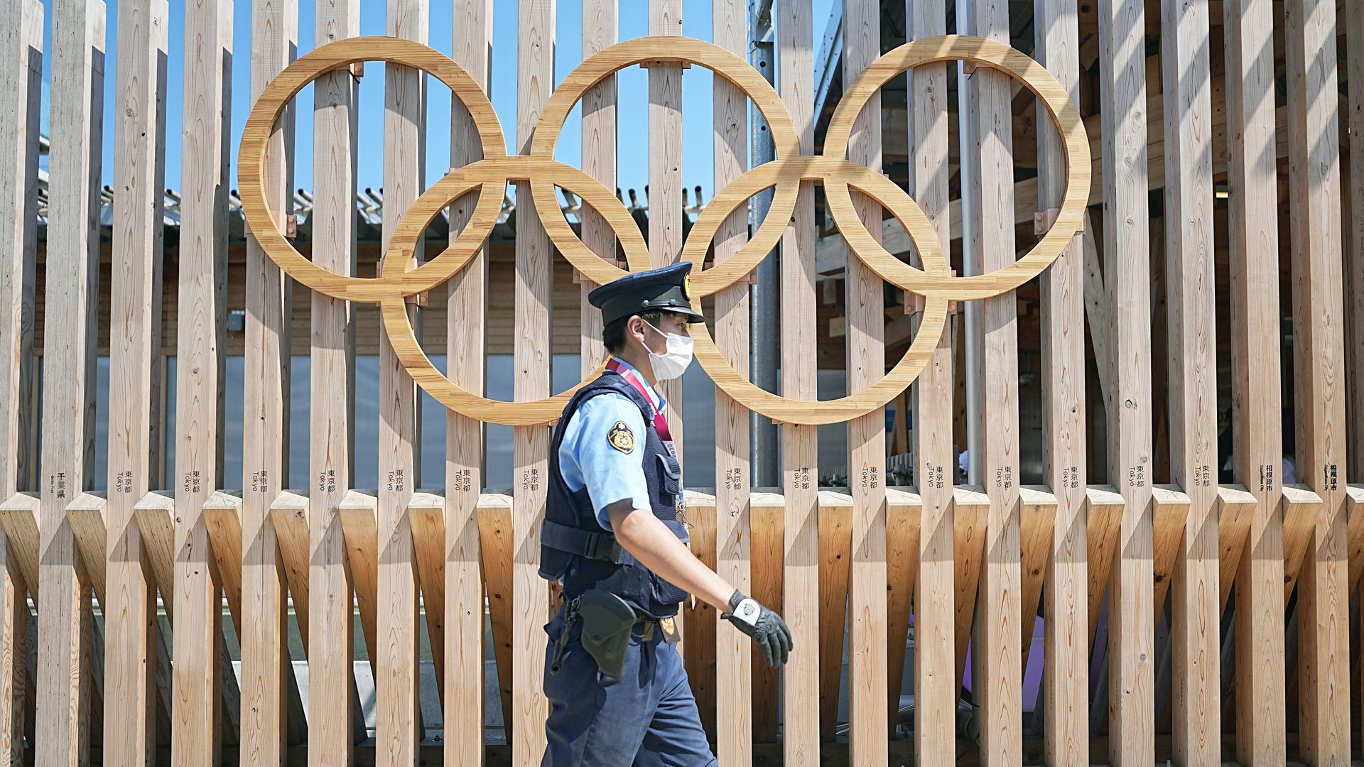 A police officer walks past Olympic rings at the entrance to Olympic Village in Tokyo, Japan, on Monday.