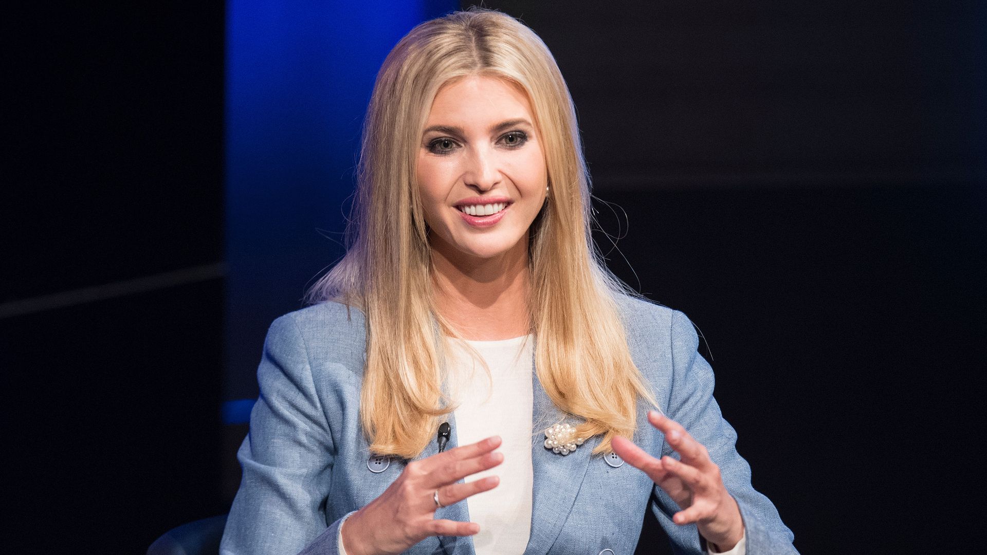 Ivanka Trump speaks enthusiastically with her hands on stage at an Axios event