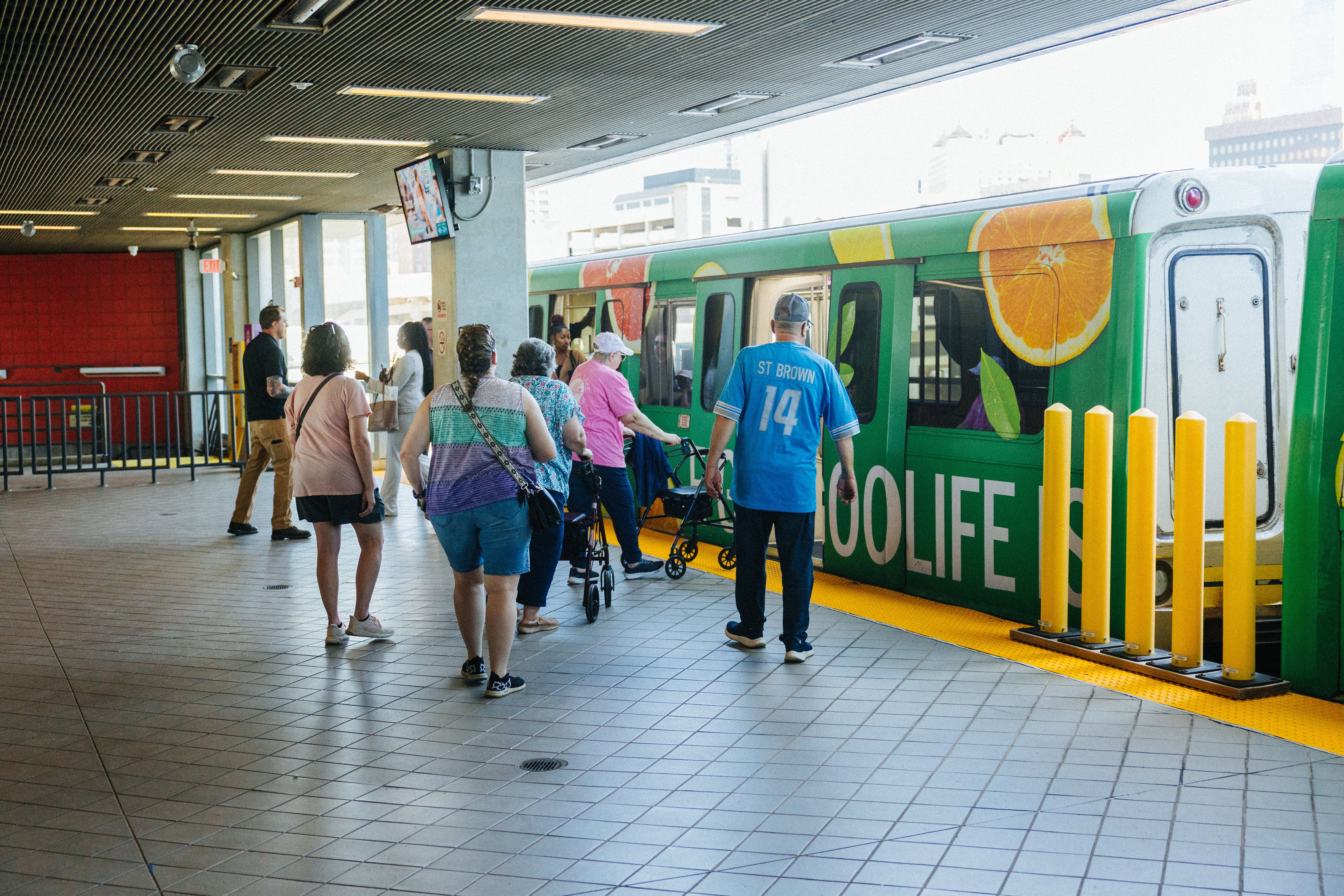 People are walking toward and getting on on a subway car-like People Mover car