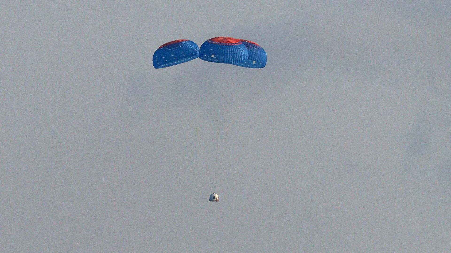 Blue Origin’s New Shepard crew capsule descends on the end of its parachute system 