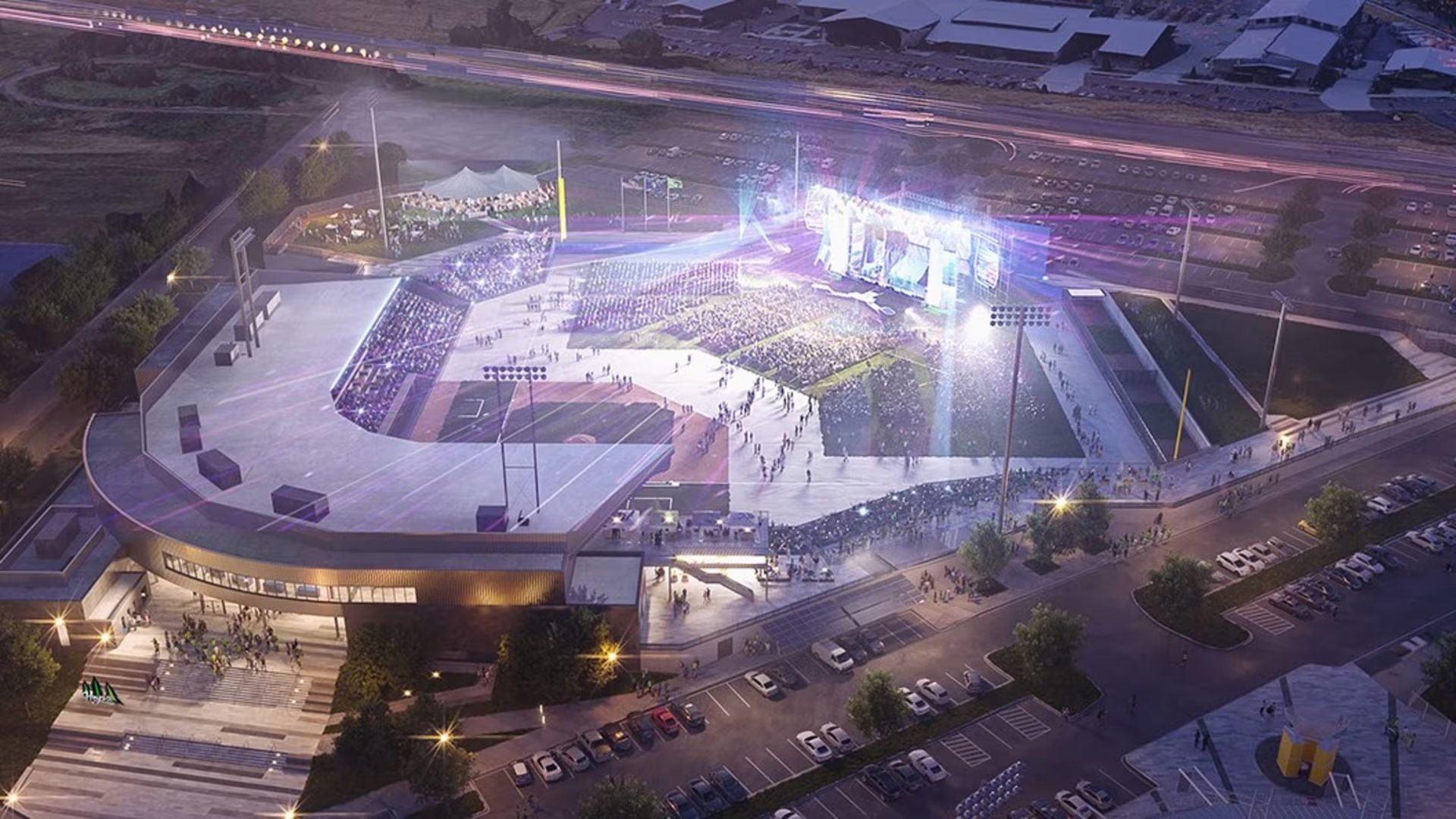 An artist's rendering of the new Hillsboro Hops stadium configured for a concert with bright stage lights, a big crowd, surrounding parking lots with cars, and a nearby highway with light trails of passing vehicles.