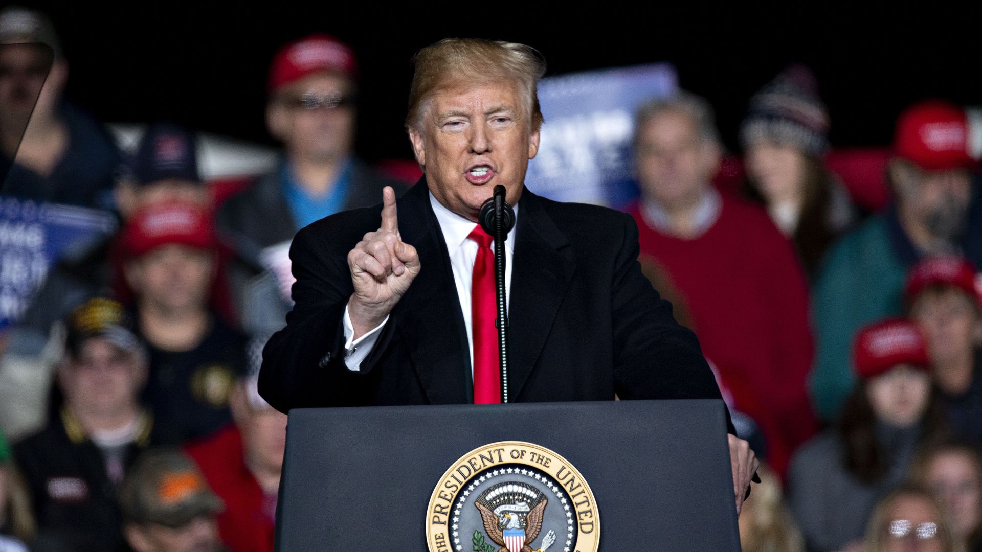 Photo of Donald Trump speaking from a podium with a finger raised