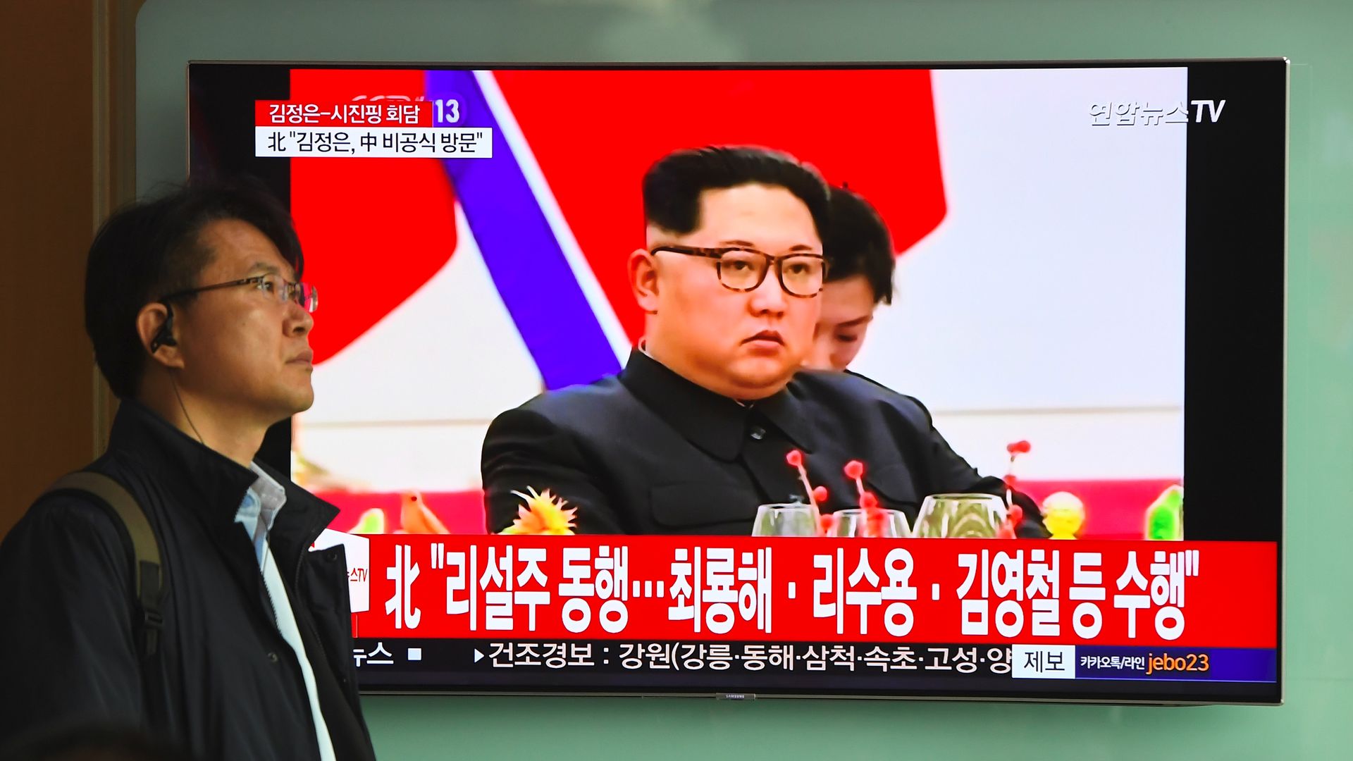 Kim Jong-un displayed on a TV with a red backdrop.