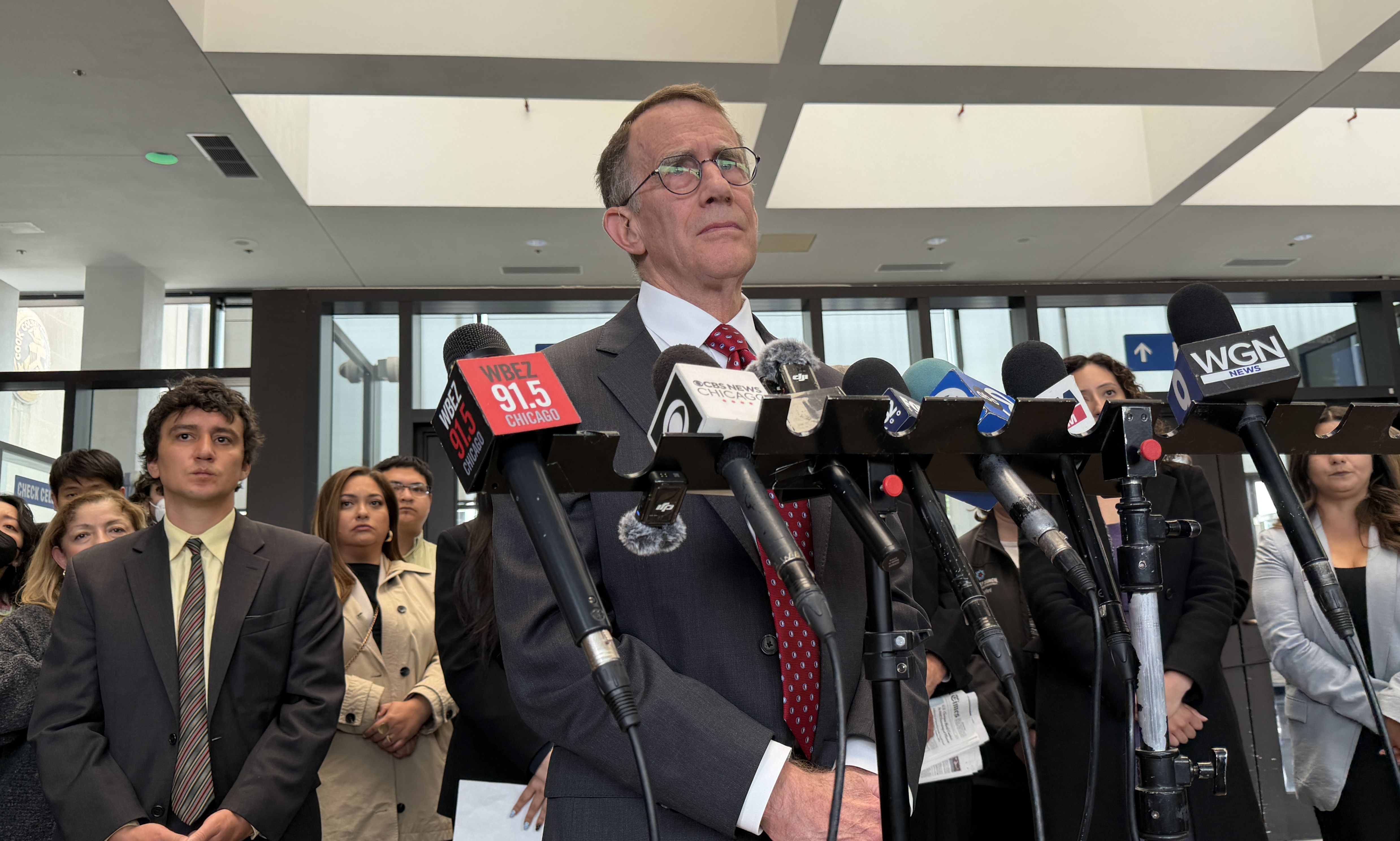 man in suit in front of cameras