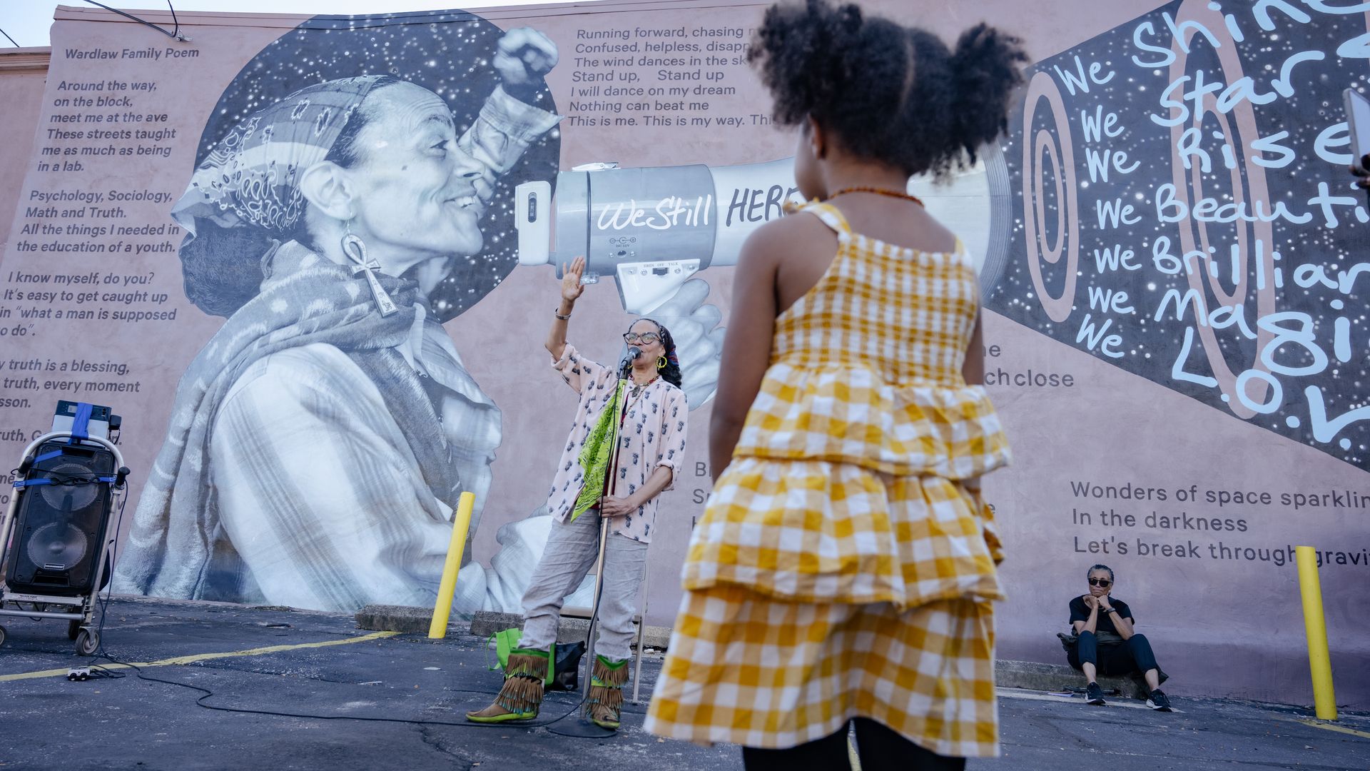 Street mural with a grayscale portrait of a woman; a woman speaking in front of a megaphone at one of the Healing Verses sessions while a girl in a yellow gingham dress watches.