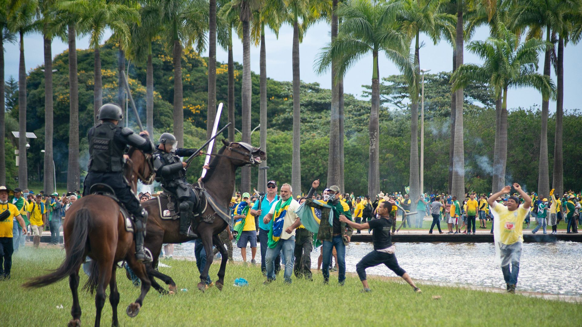 throngs of rioters attack two police officers on horseback 