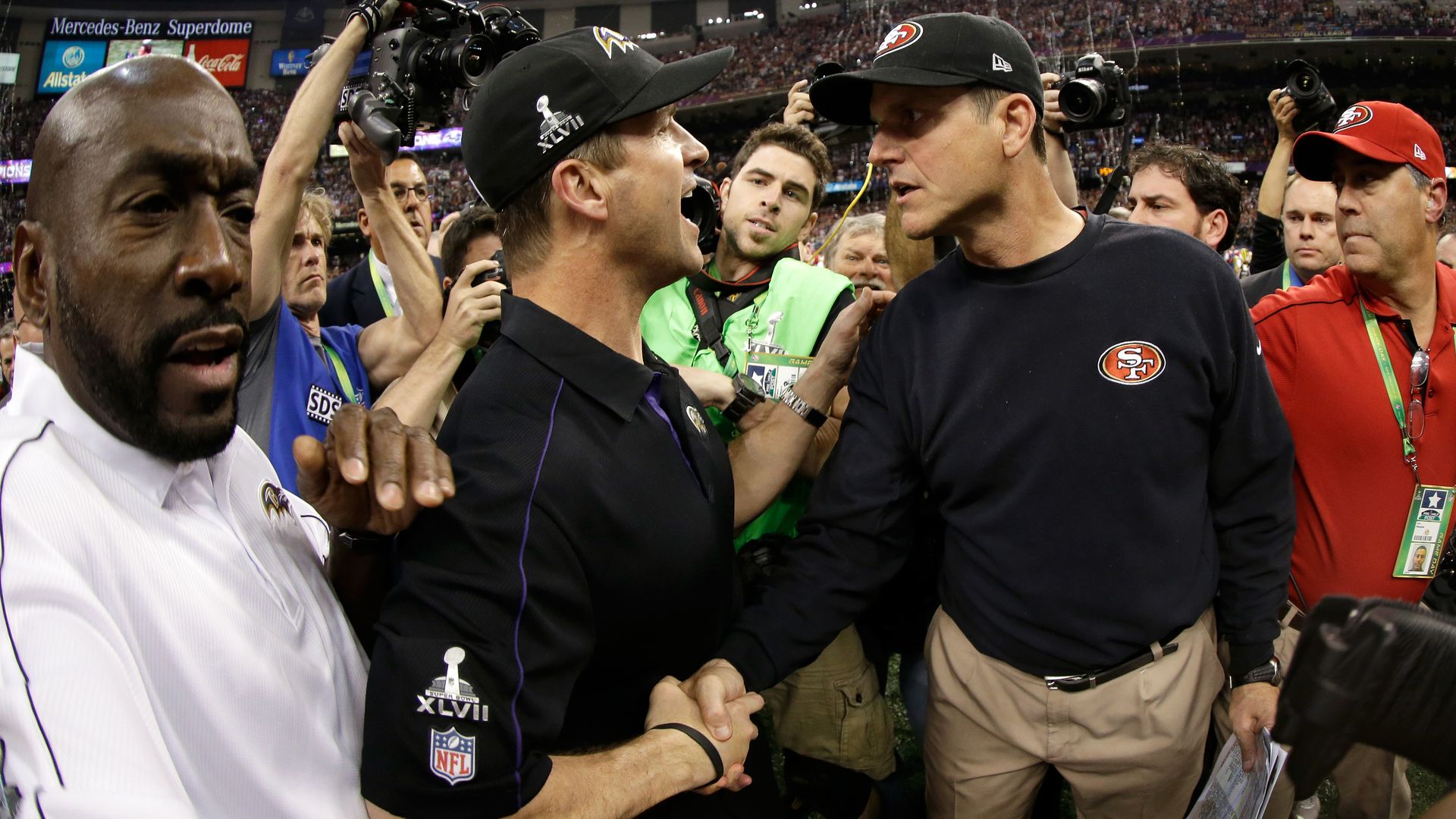 Photo of Jim and John Harbaugh embracing on the field