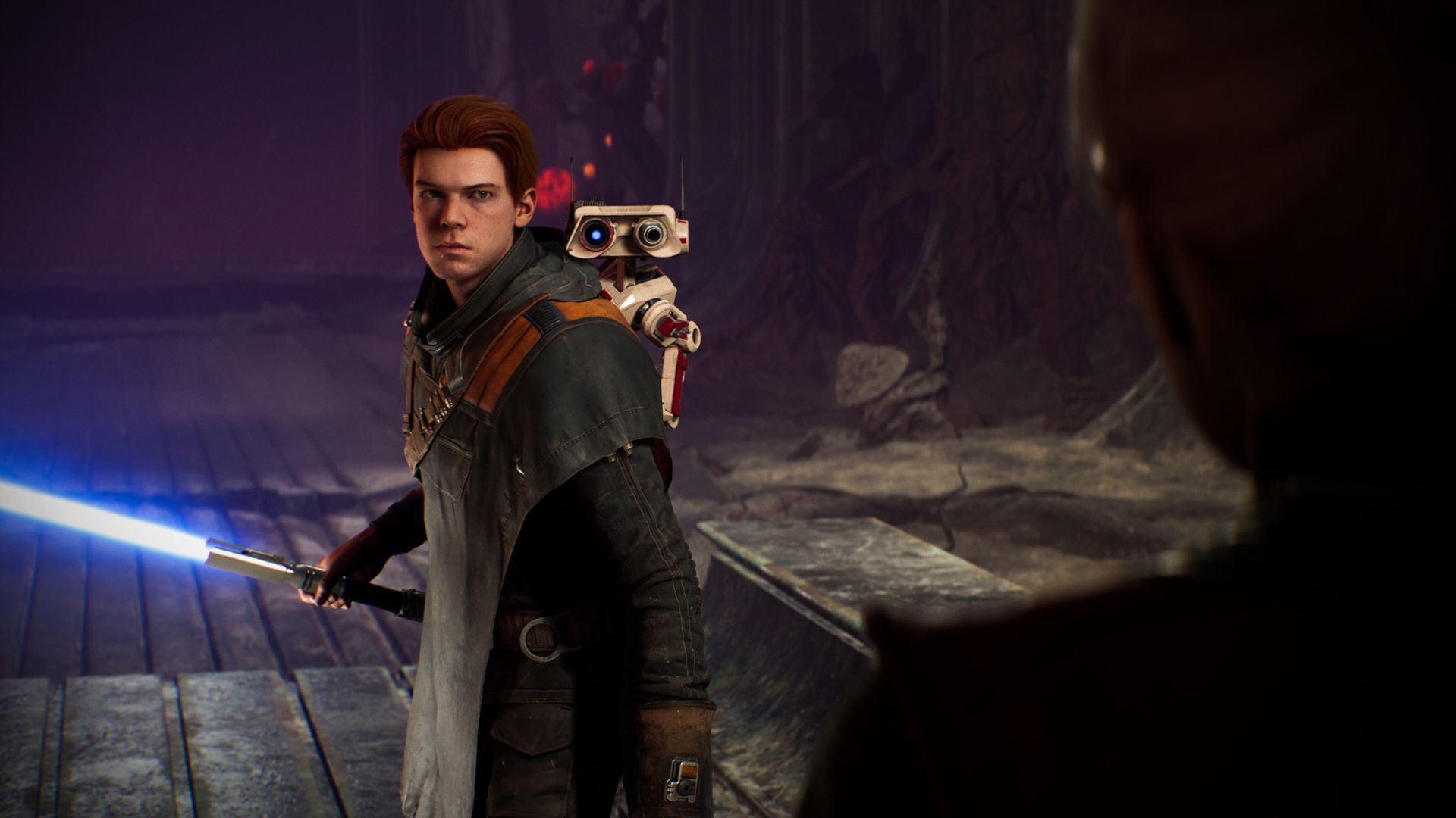 Image of an animated video game scene showing a redheaded Jedi wielding a lightsaber and carrying a small robot on their back