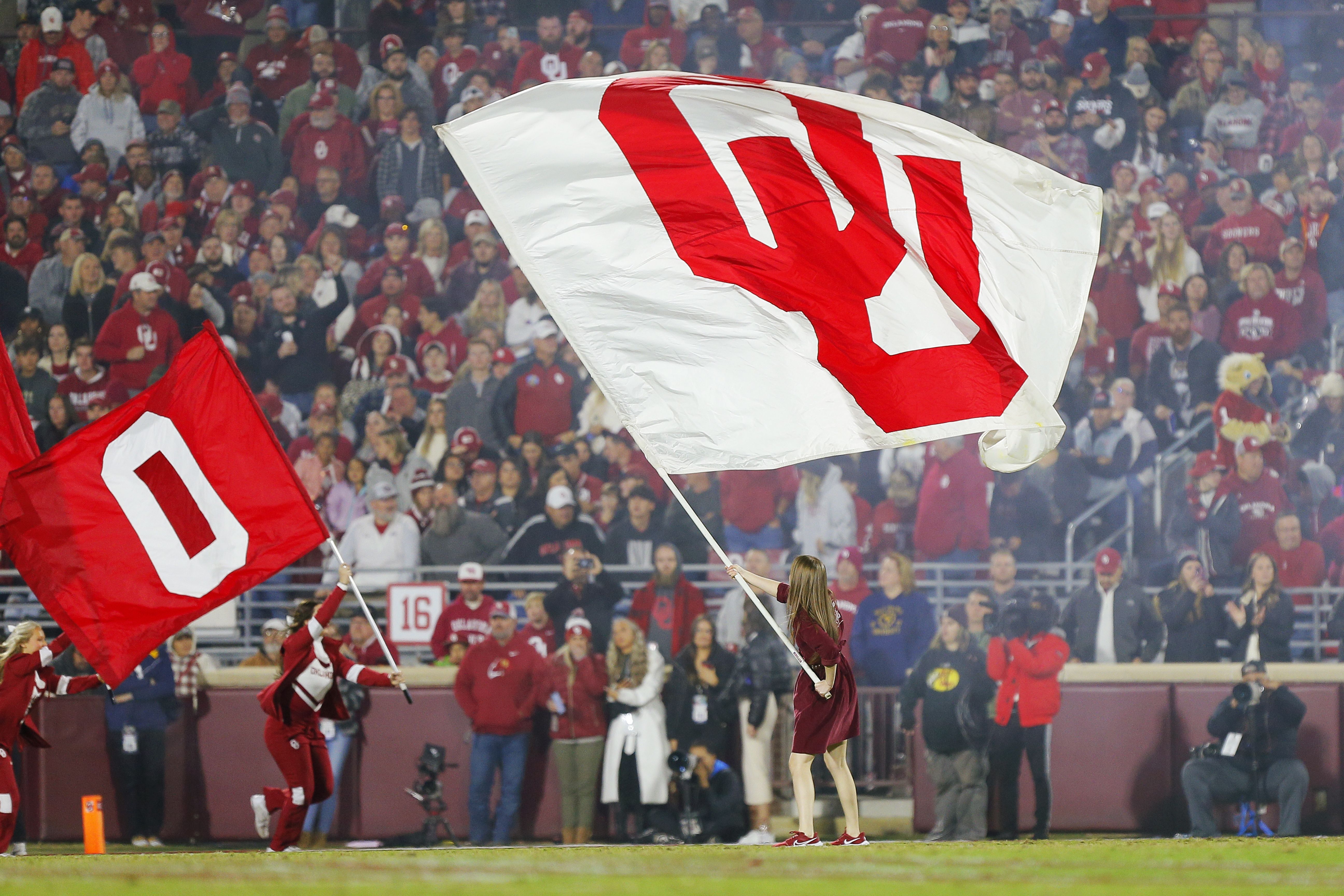 Flags wave on a football field during an Oklahoma game. 