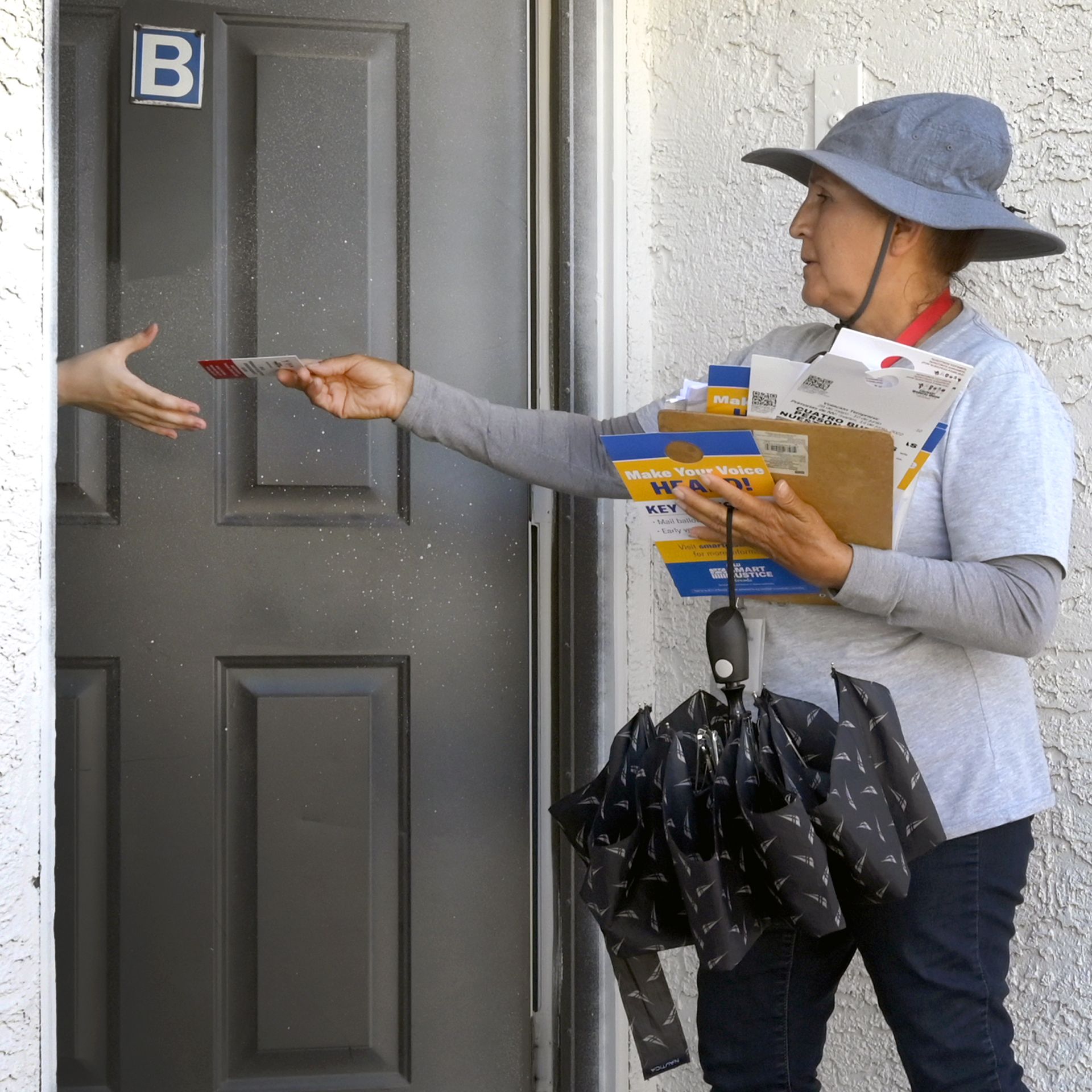 A Culinary Union member in Nevada canvasses voters at an apartment complex, carrying multiple pamphlets