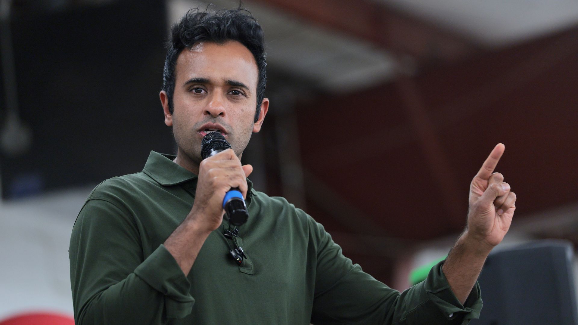 Vivek Ramaswamy stands on stage with a microphone