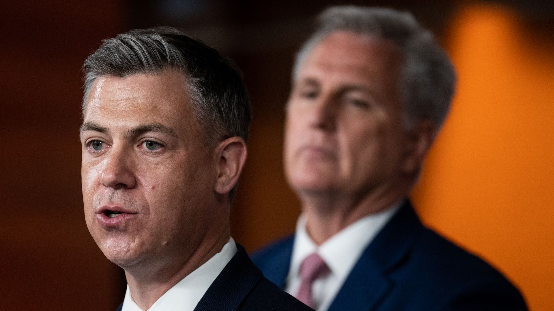 Rep. Jim Banks (R-Ind.) speaks with Minority Leader Kevin McCarthy out of focus in the background.