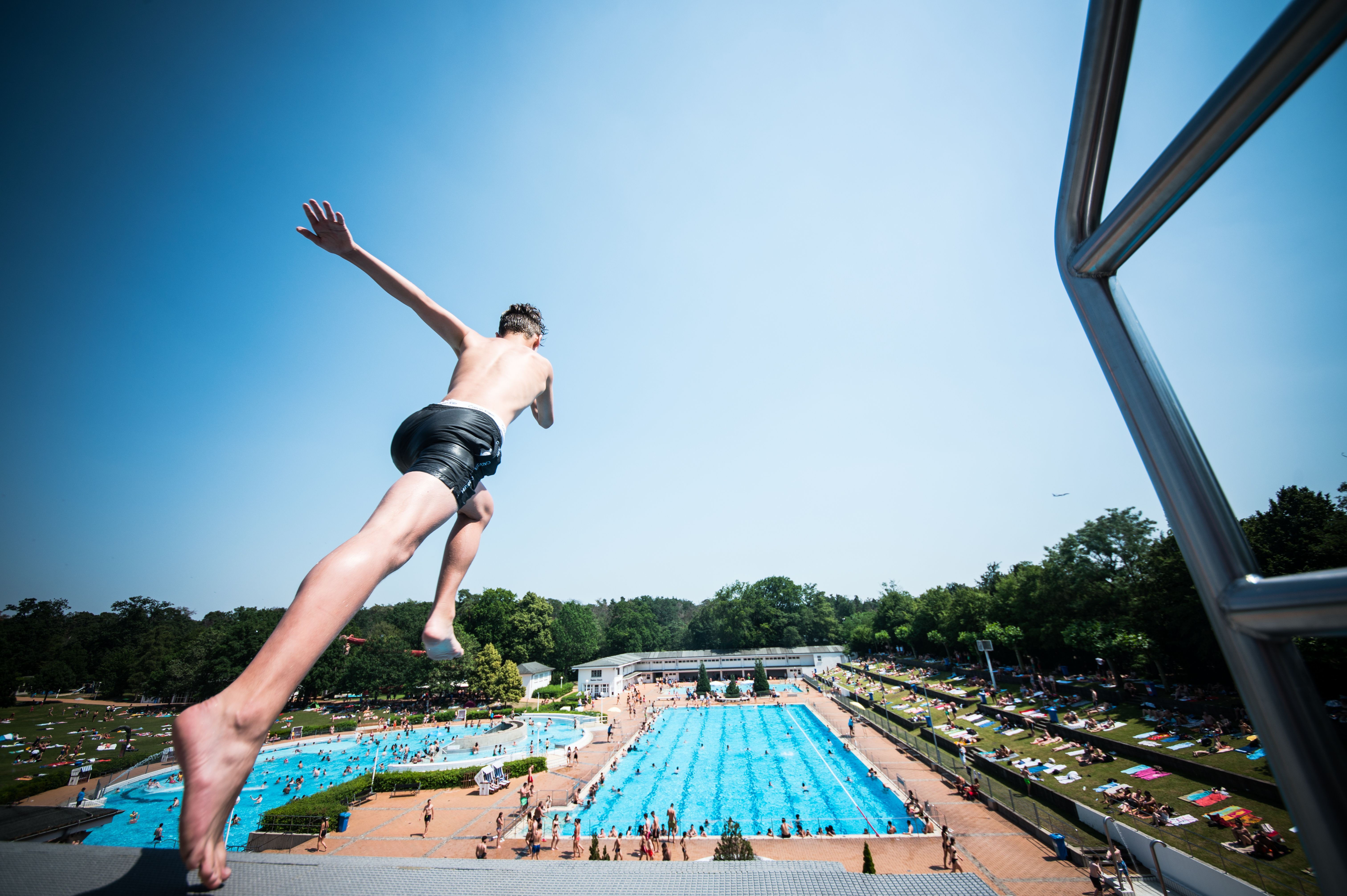 A boy jumps from a diving board in to a swimming pool in Frankfurt am Main, western Germany on June 26.