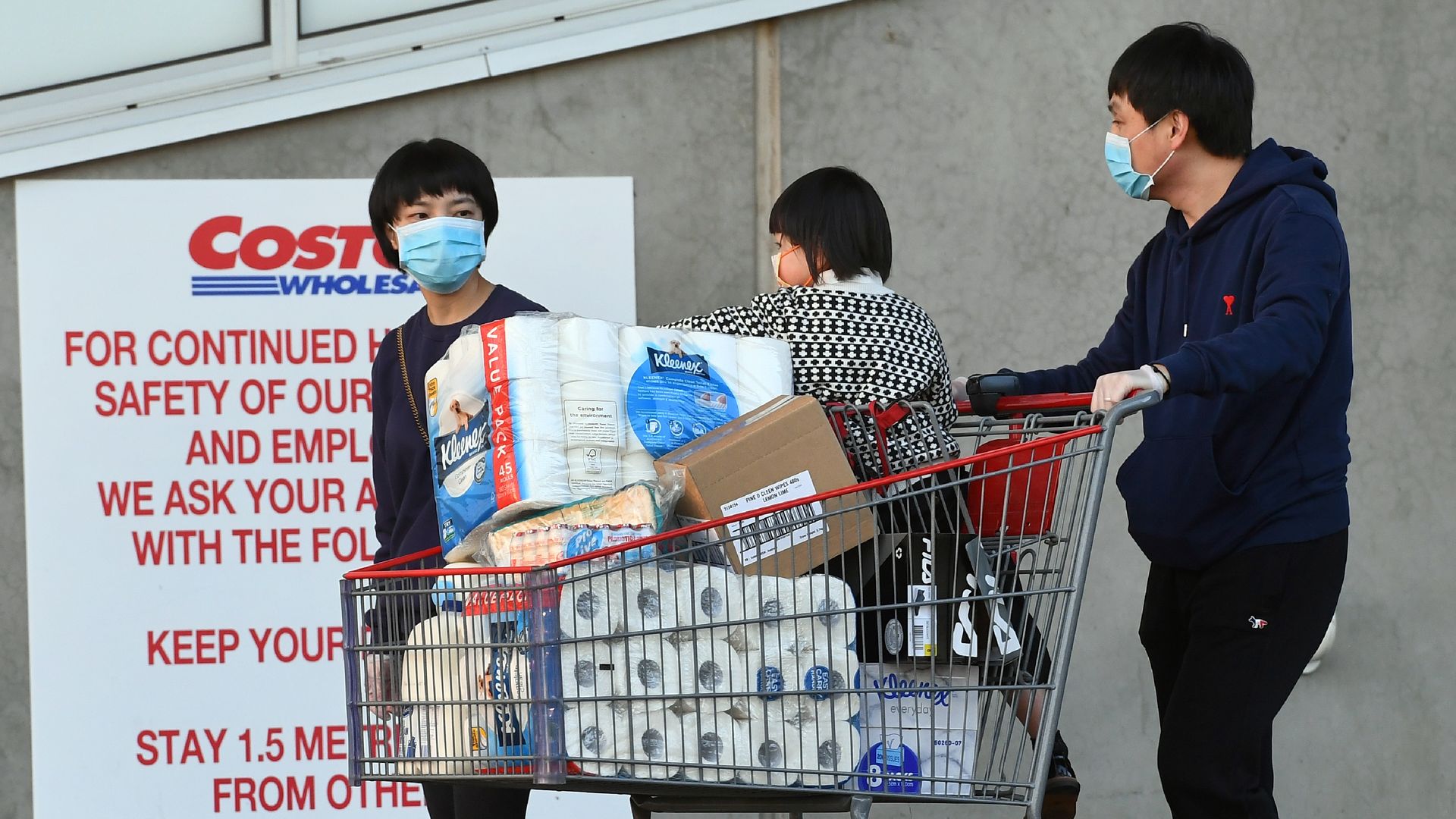 A family leaving Costco with toilet paper