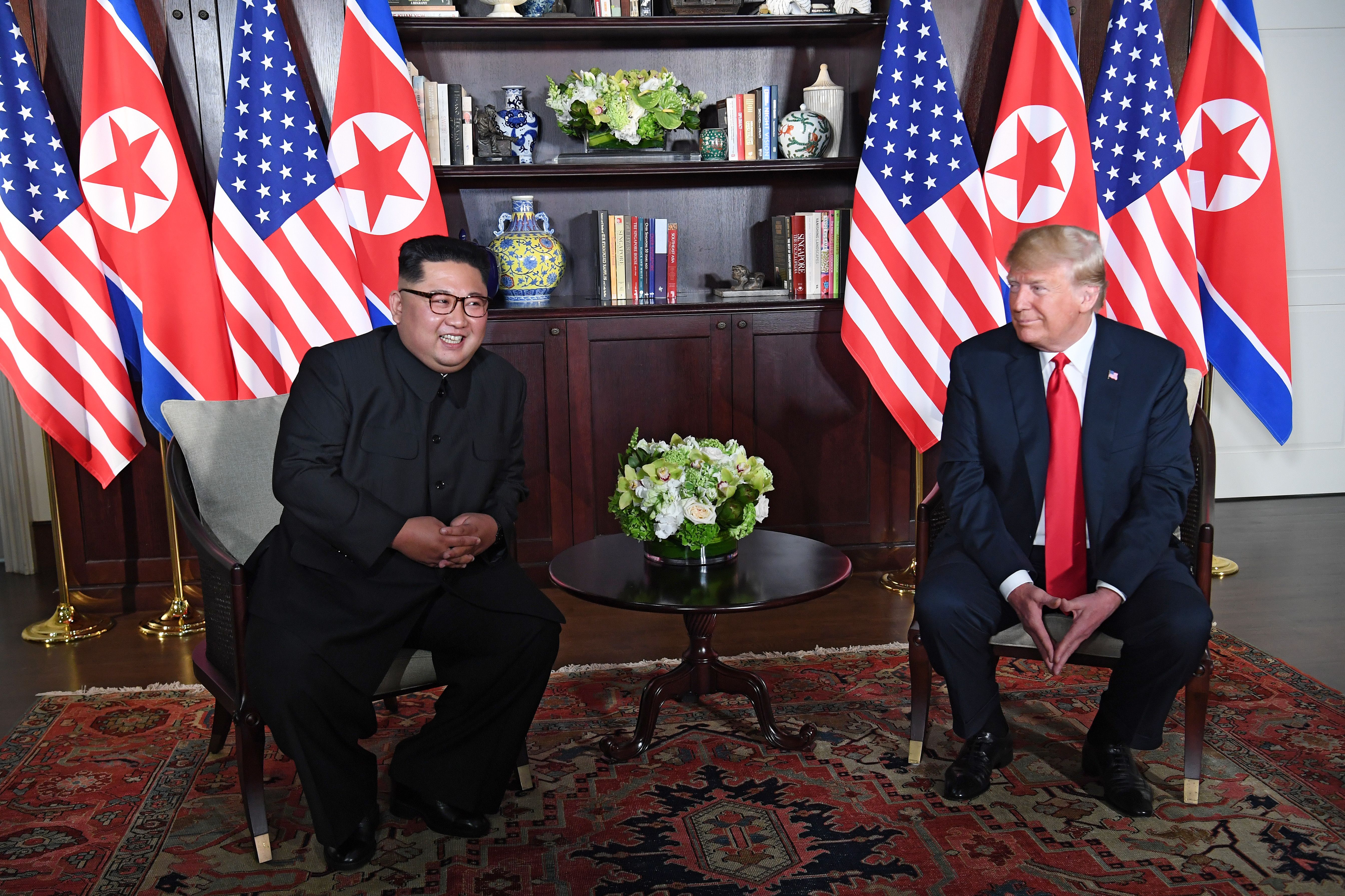 Trump and Kim smile across from each other ahead of their meeting