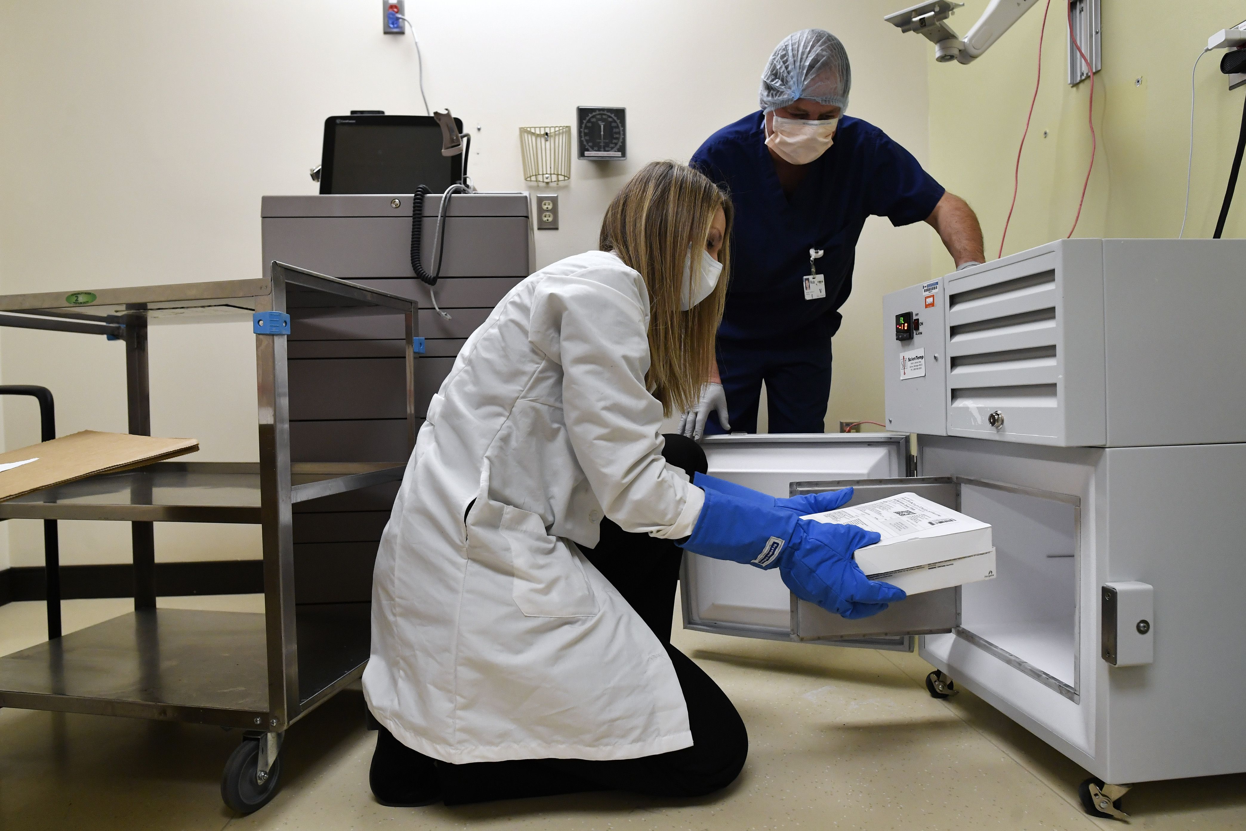 Vail Health Hospital pharmacy pharmacist Jessica Peterson, left, places two boxes of mock Covid-19 vaccines into the hospital's ultra-cold freezer at the hospital on Dec. 8