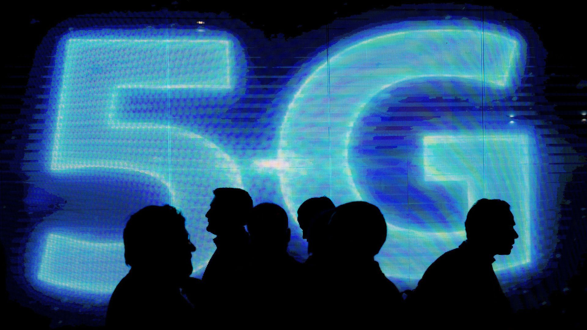 People in shadow before a 5G logo