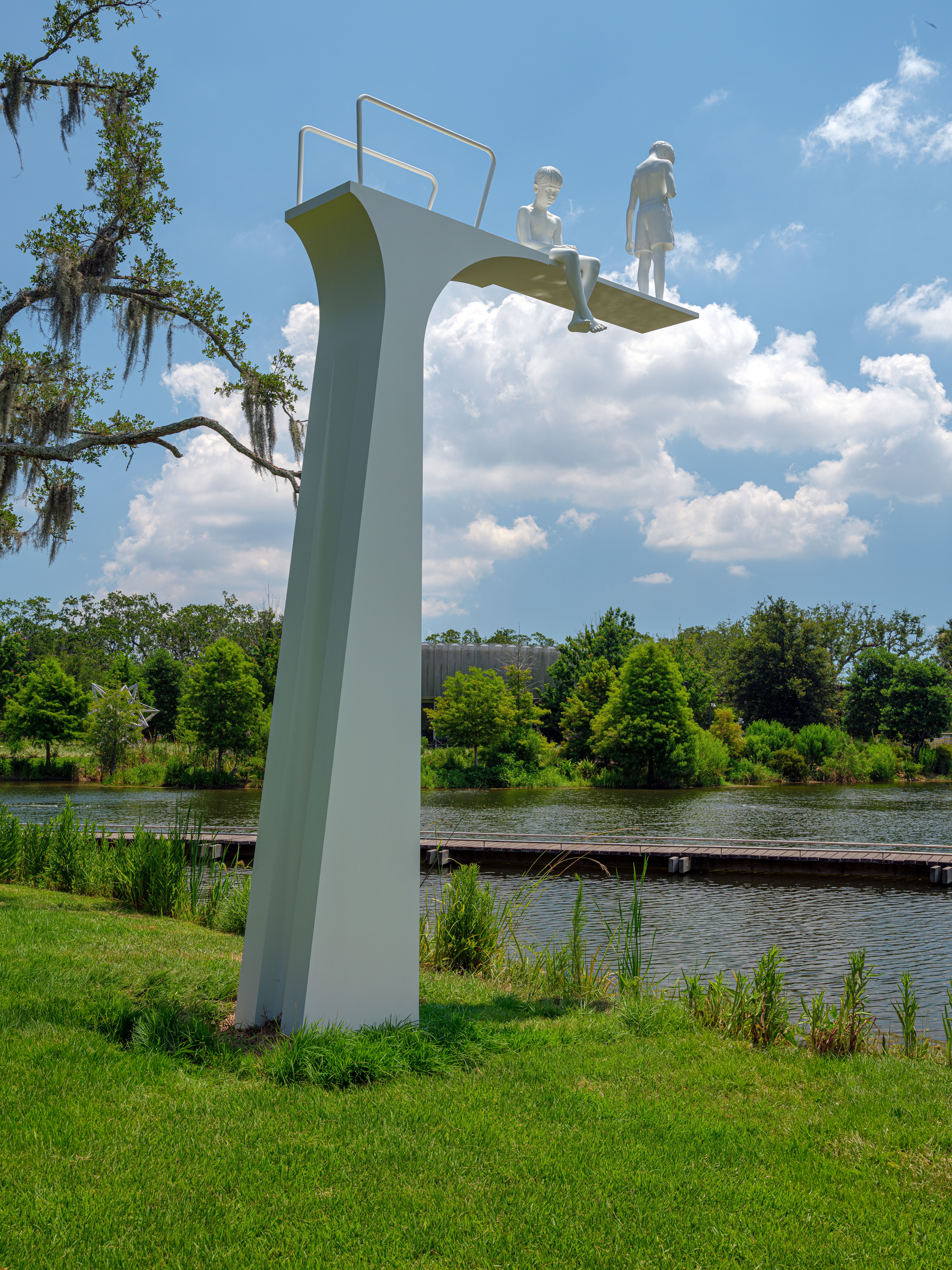 Photo shows a diving board sculpture with two people on top.