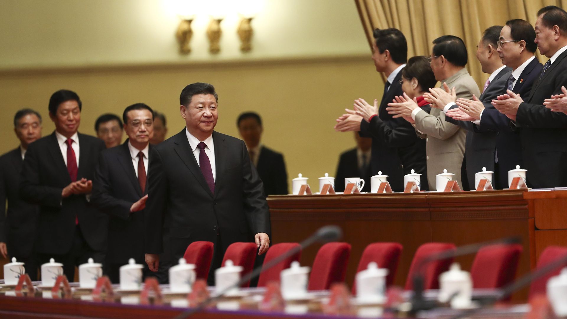 Chinese President Xi Jinping walking through his party headquarters with people clapping