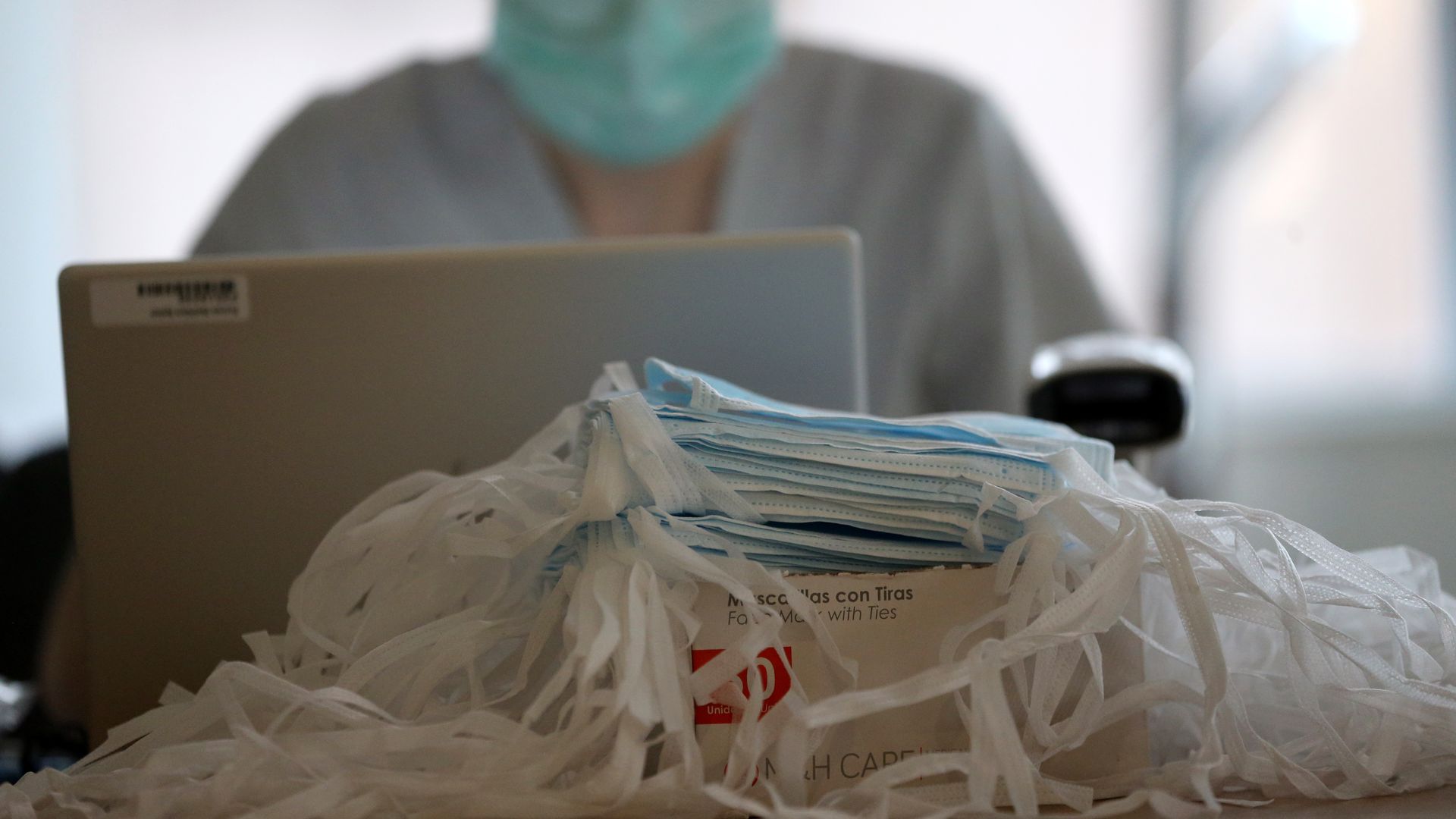 Pile of masks in front of a health care worker