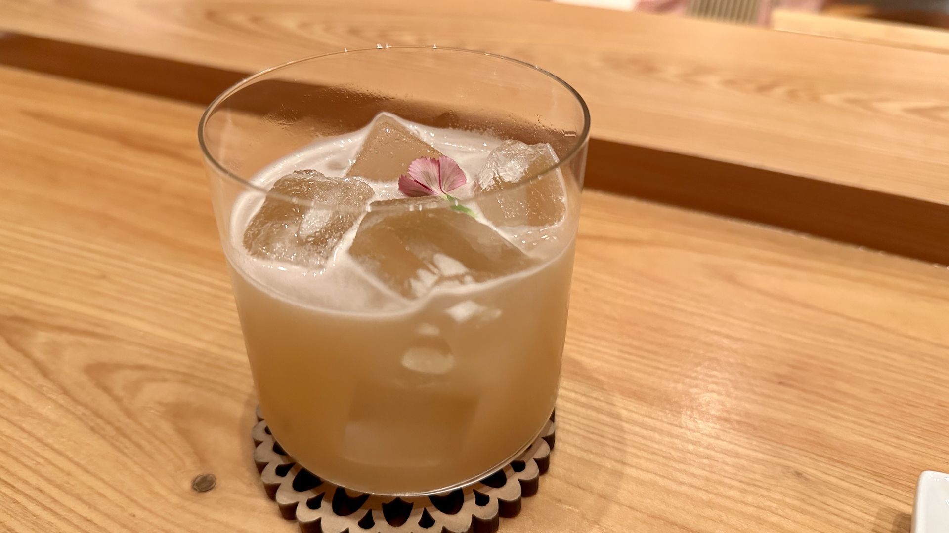 A hazy rice mocktail in a glass on a bar