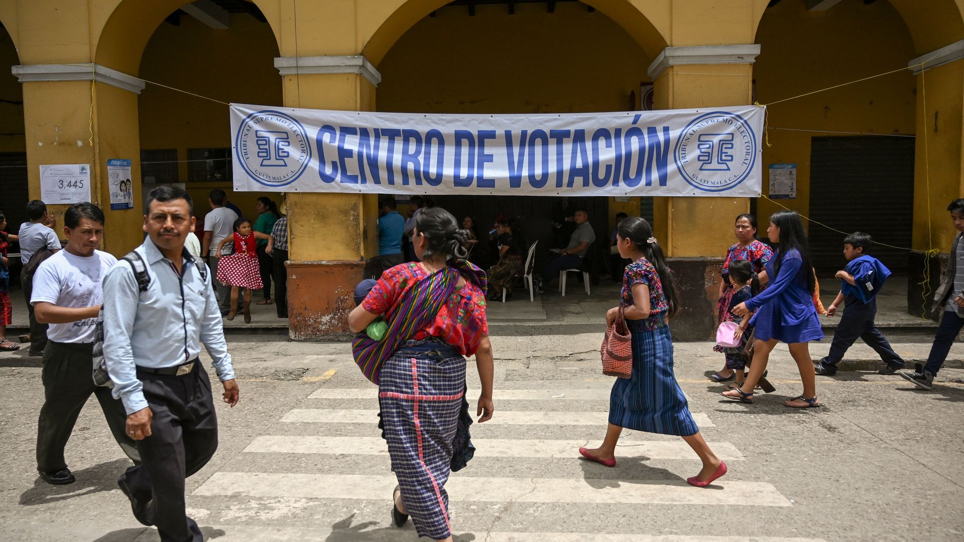 Guatemalans walking outside a polling center
