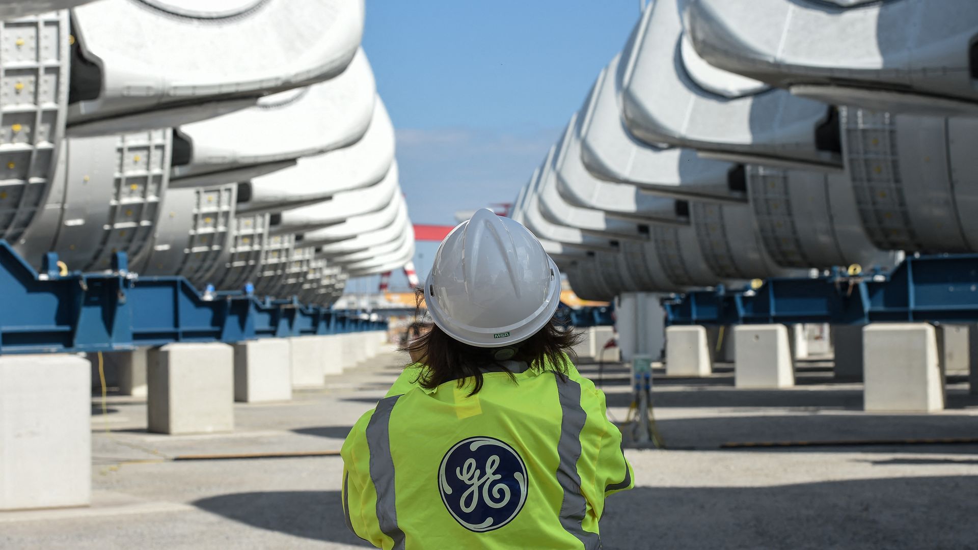 A General Electric employee between wind turbine nacelles during the construction of a wind farm near Saint-Nazaire, France, in September 2021.
