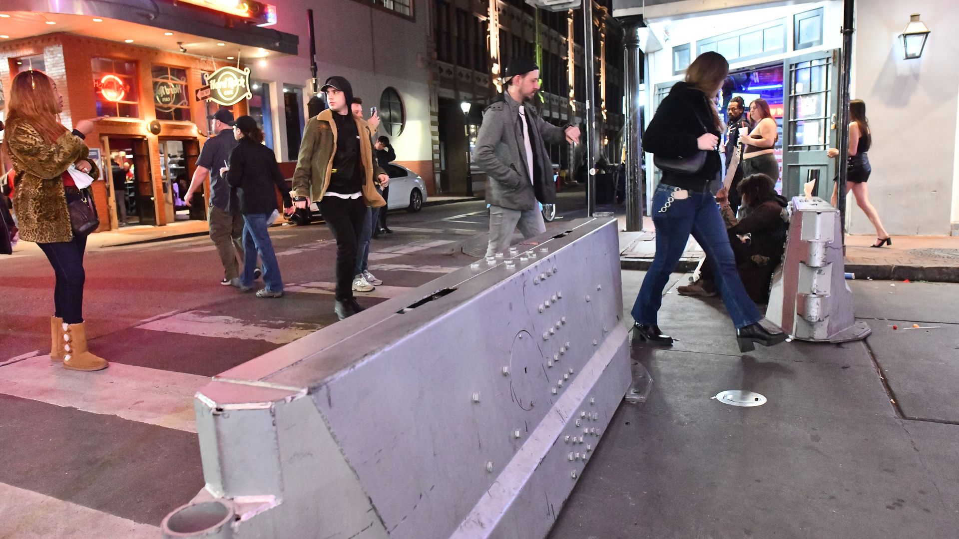 Image shows a vehicle barricade on Bourbon Street with people walking around it.