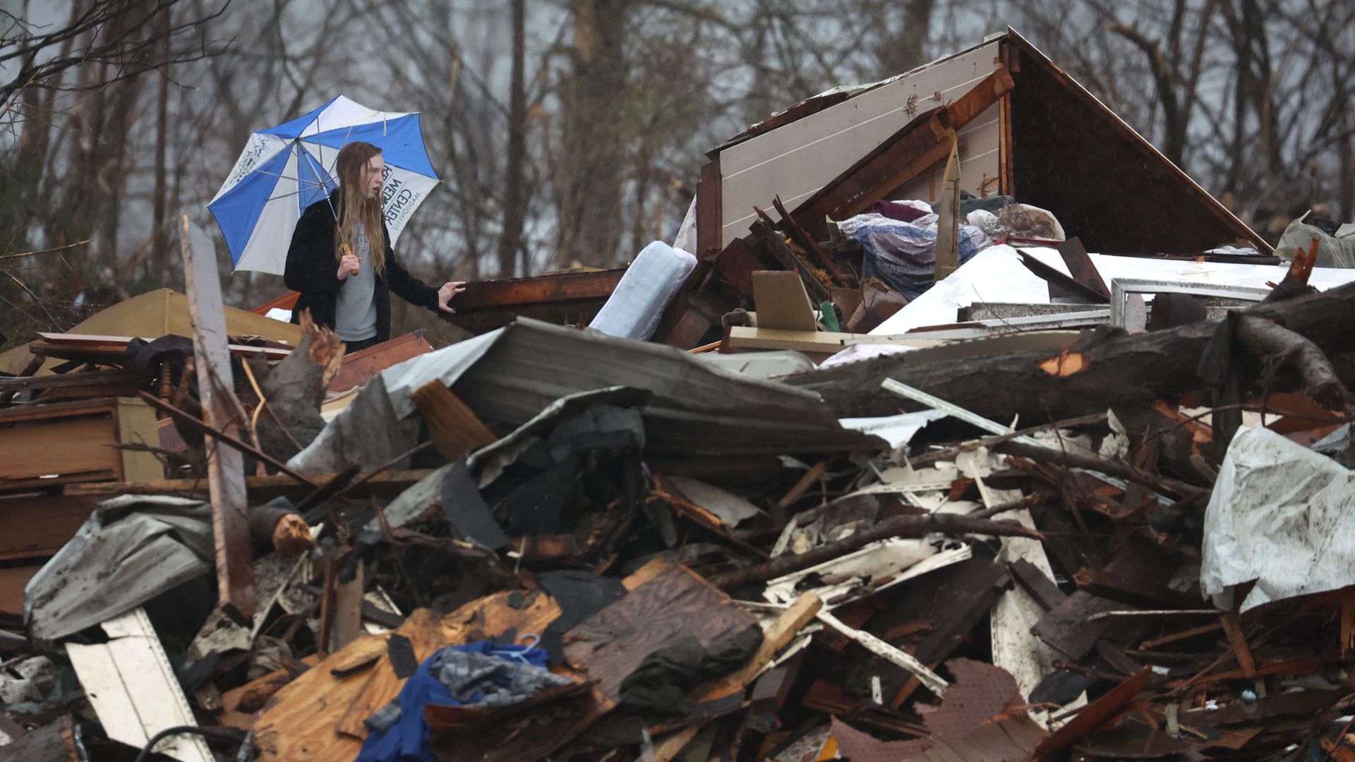  Loren Grable searches in the rain for mementoes in rubble that was once her grandparents' home before it was destroyed during last week's tornado on December 16, 2021 in Dawson Springs, Kentucky.