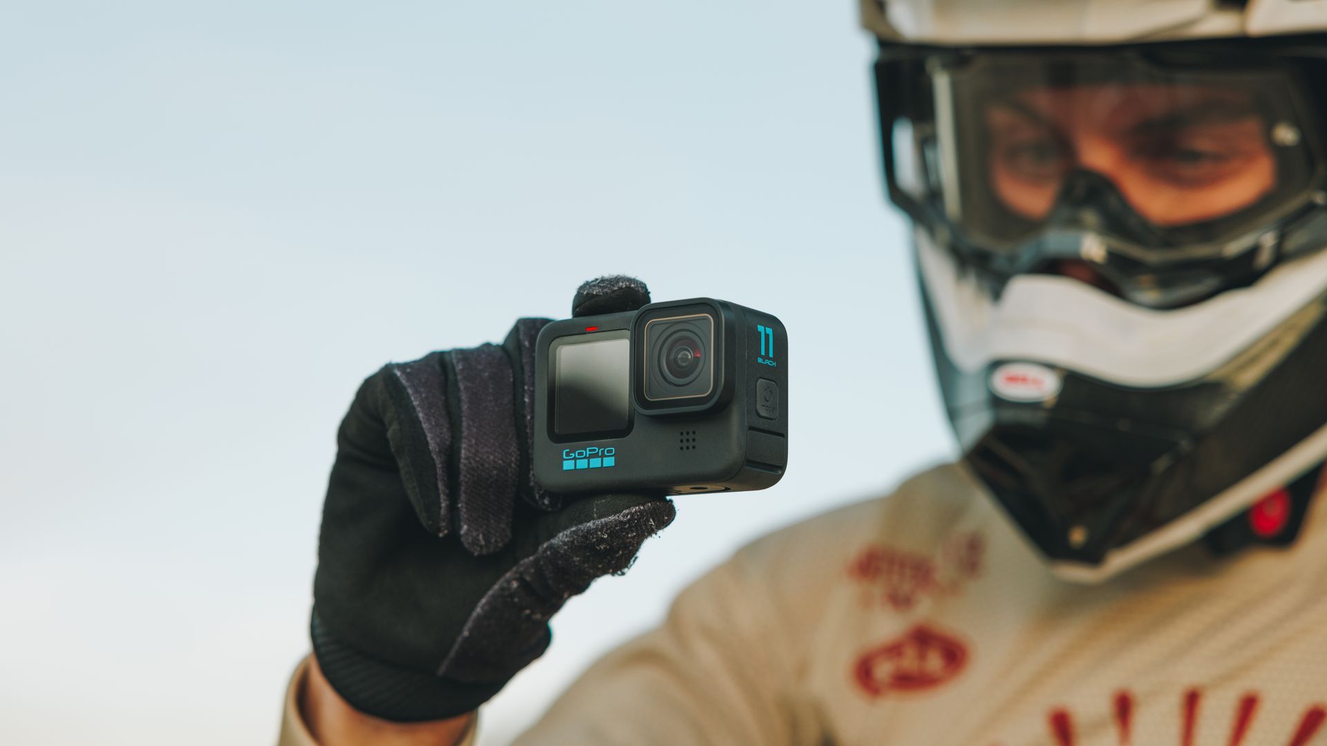 A cyclist holds a GoPro Hero 11 Black camera