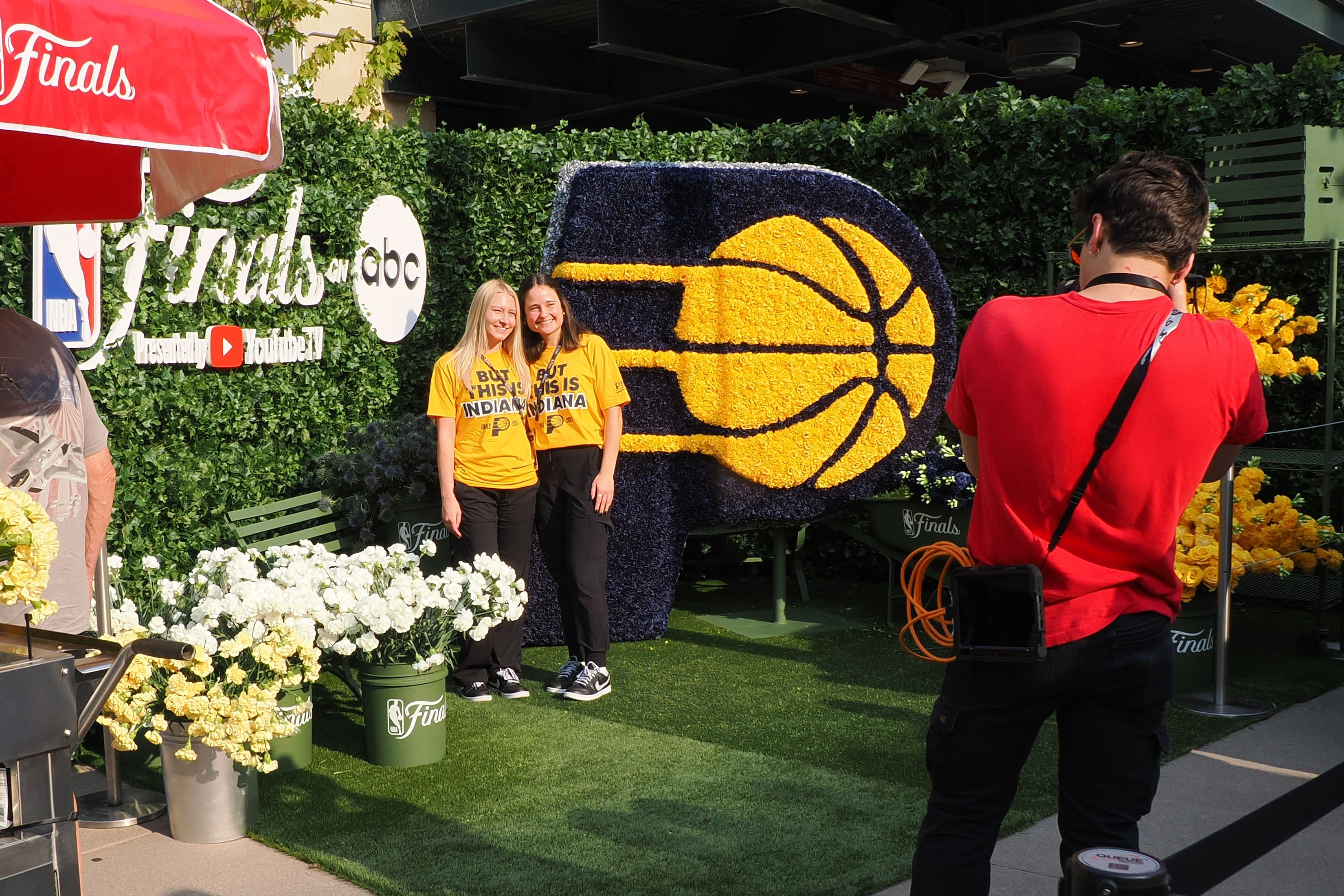 People posing in front of a floral installation
