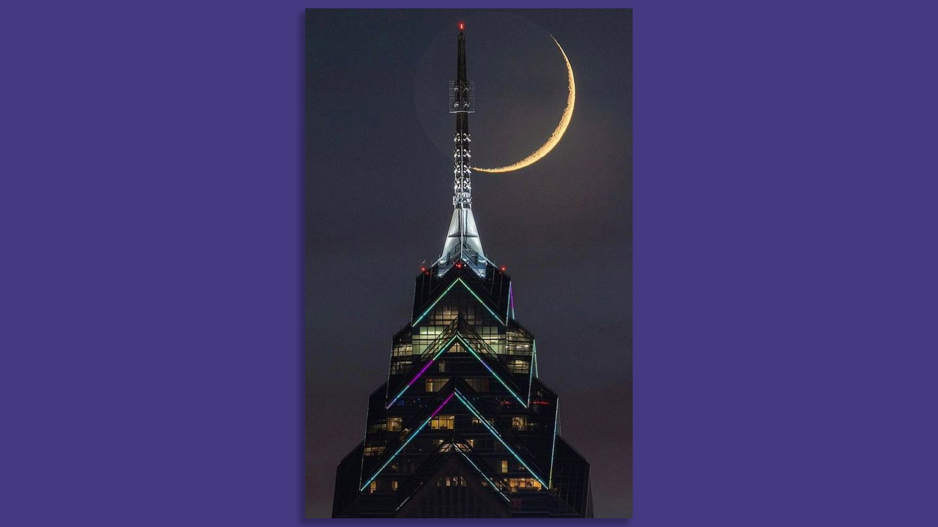 The light system atop One Liberty Place is seen here with a crescent moon shining behind it.