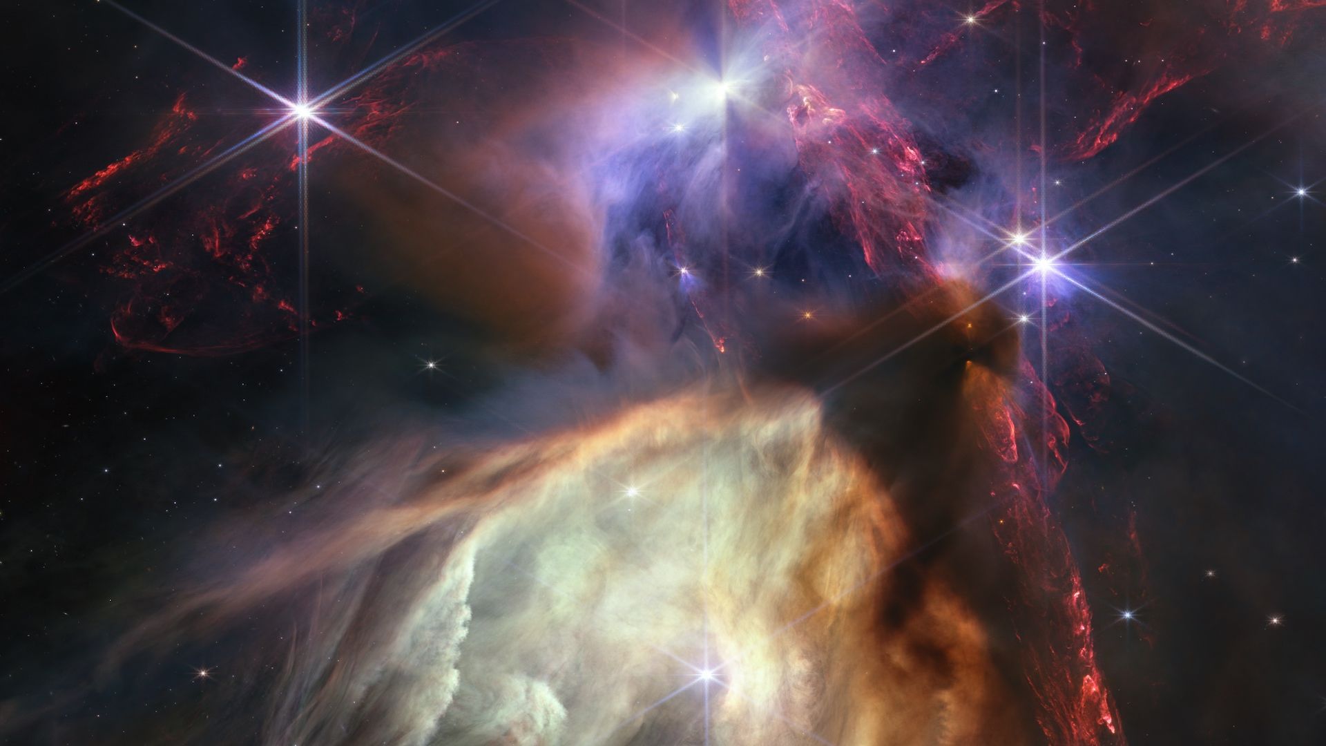 A group of young stars in colorful clouds of gas and dust seen by the JWST