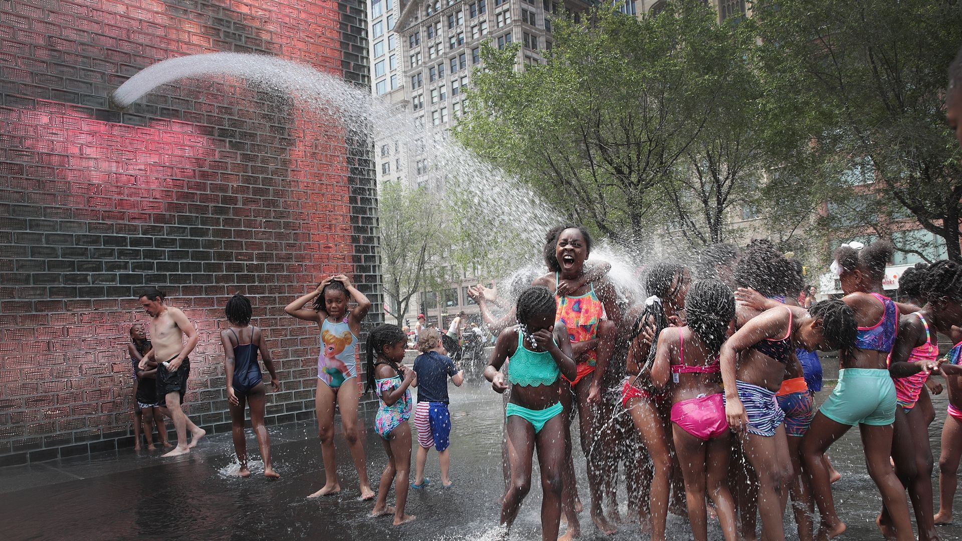 Children cool off in Crown Fountain in downtown Chicago as temperatures rise