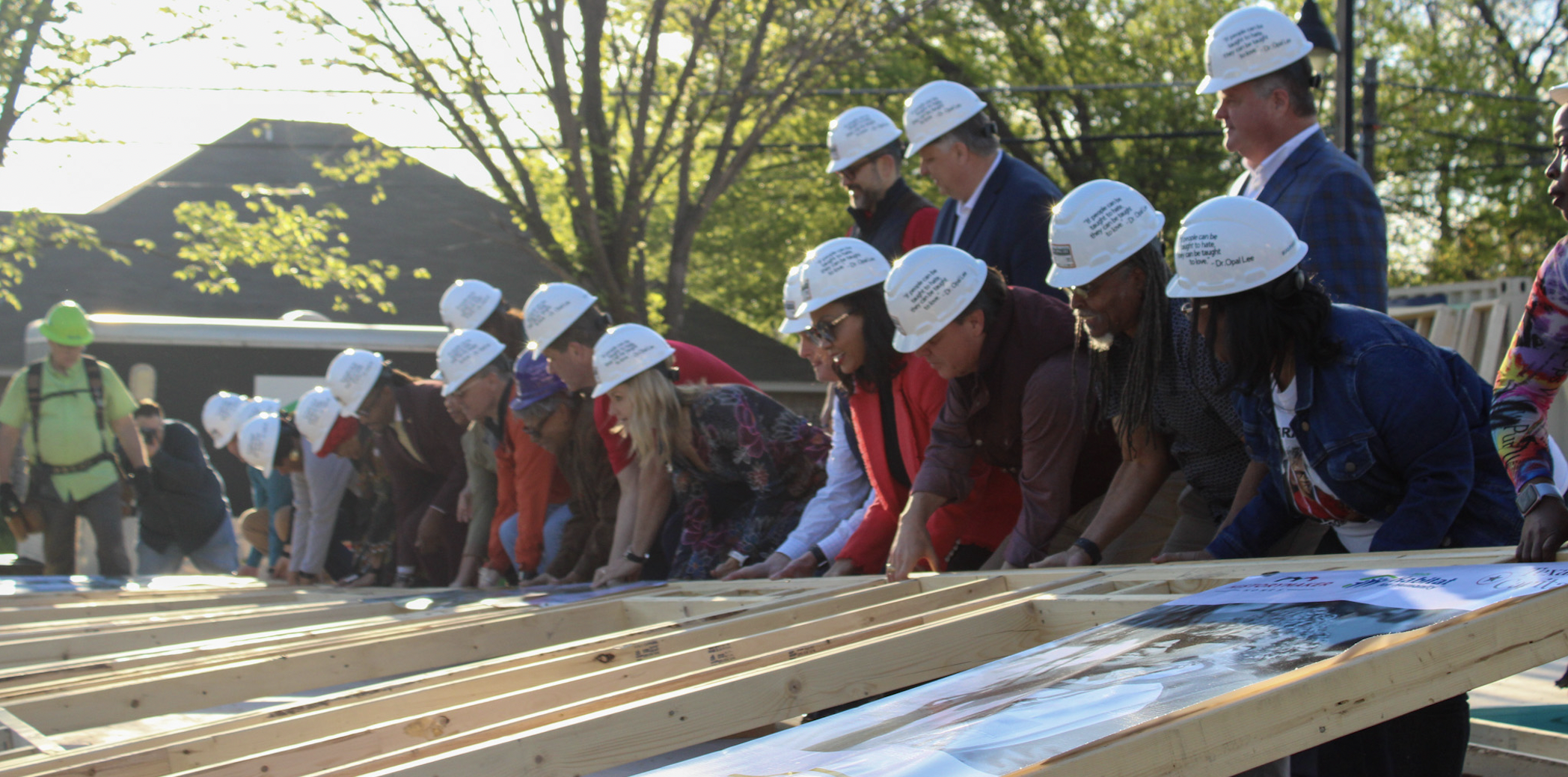 People lifting up the wooden framing of a house