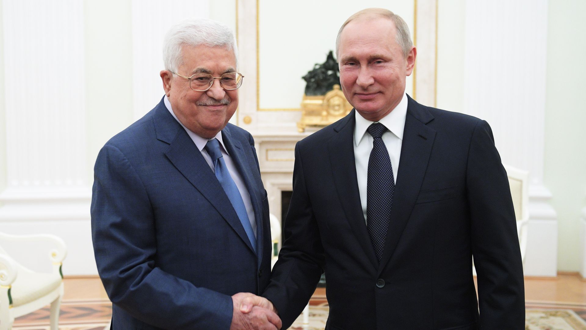 Mahmoud Abbas and Putin shake hands.