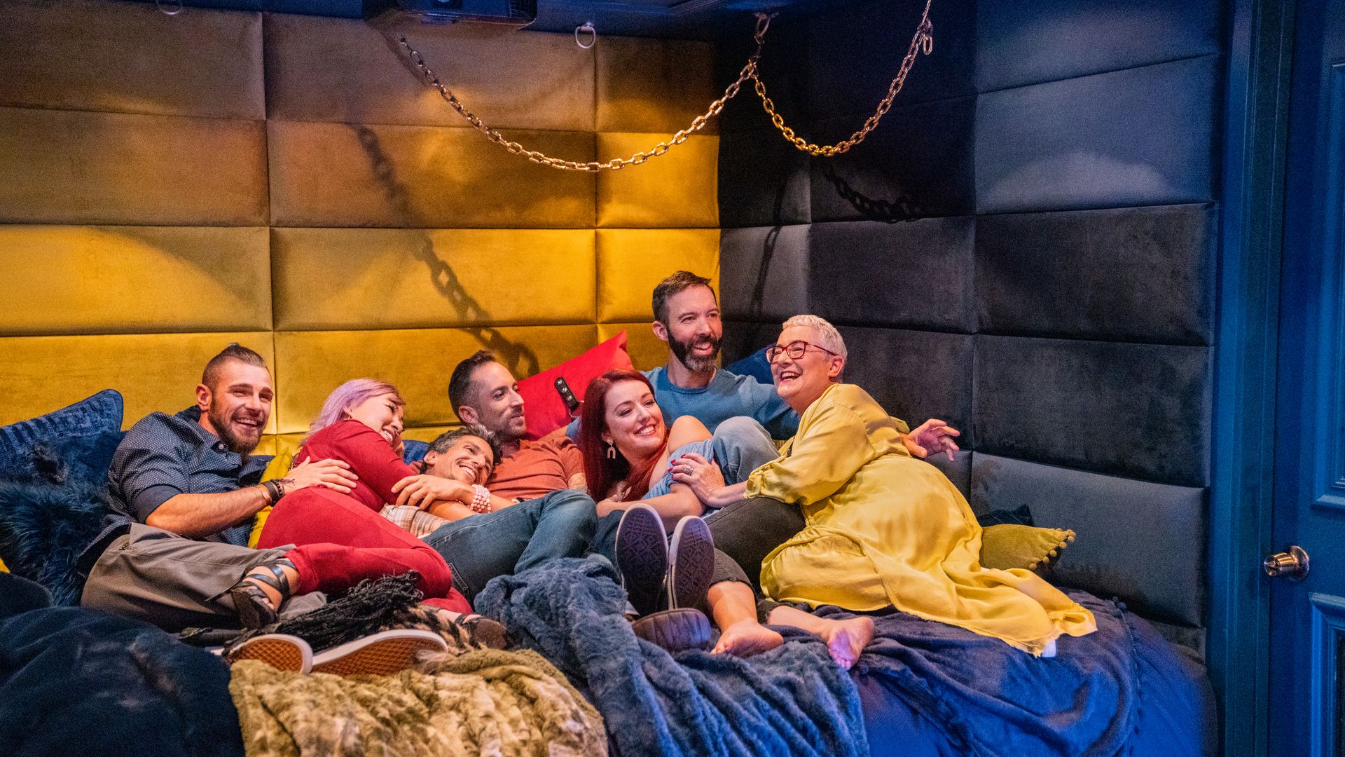 seven people cuddle in a bed