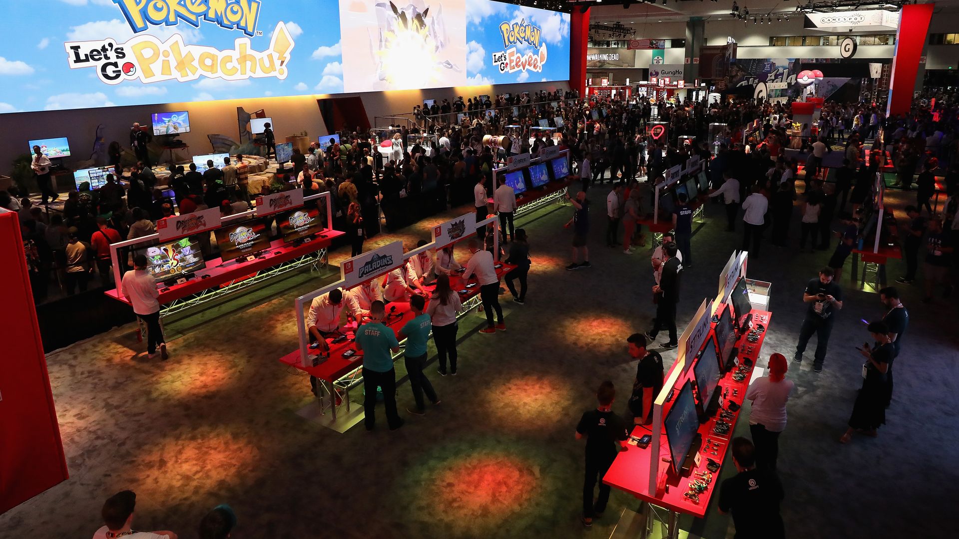 A photo of a trade show floor filled with rows of kiosks running a Pokemon game
