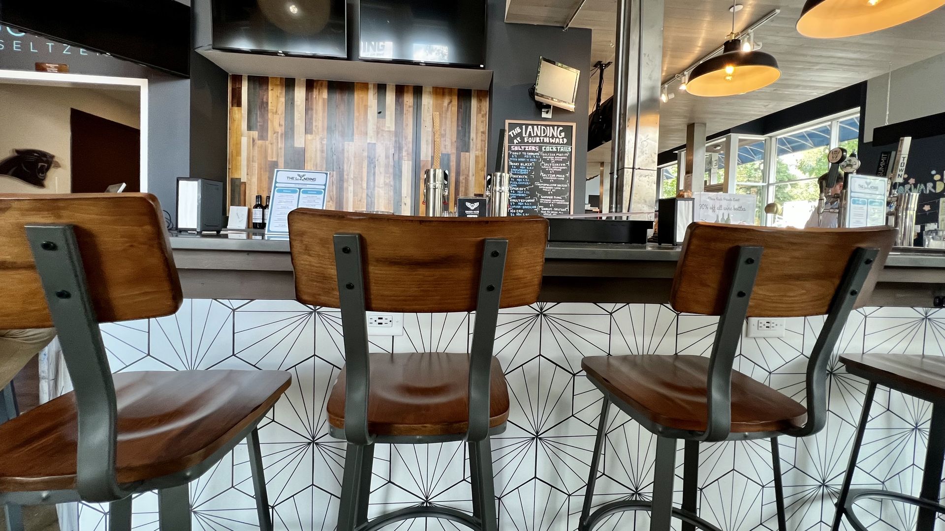 Bar with three stools in front of it