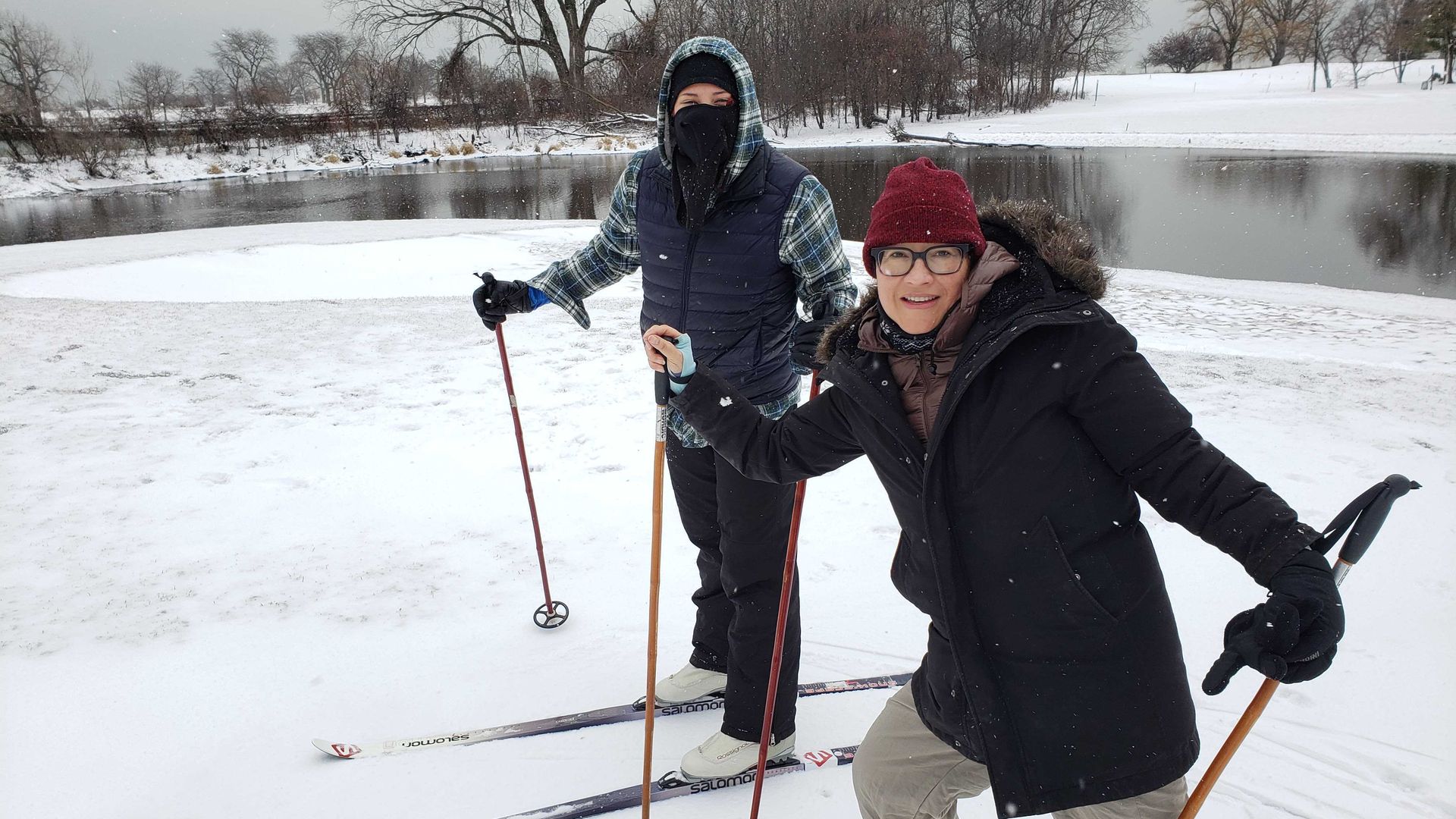 A photo of two people skiing. 