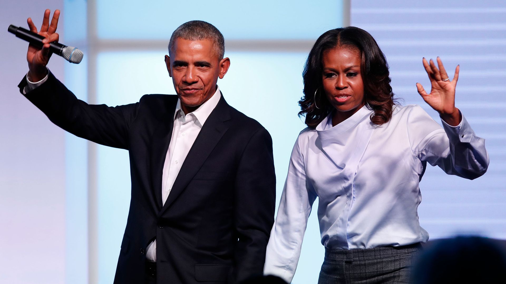 Barack and Michelle Obama wave to the crowd at the Obama Foundation Summit. 