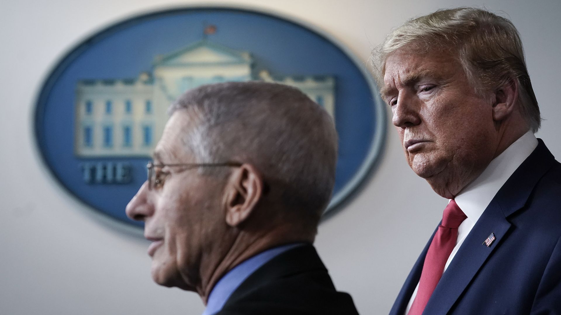 Anthony Fauci (L), director of the National Institute of Allergy and Infectious Diseases, speaks as U.S. President Donald Trump looks on during a briefing