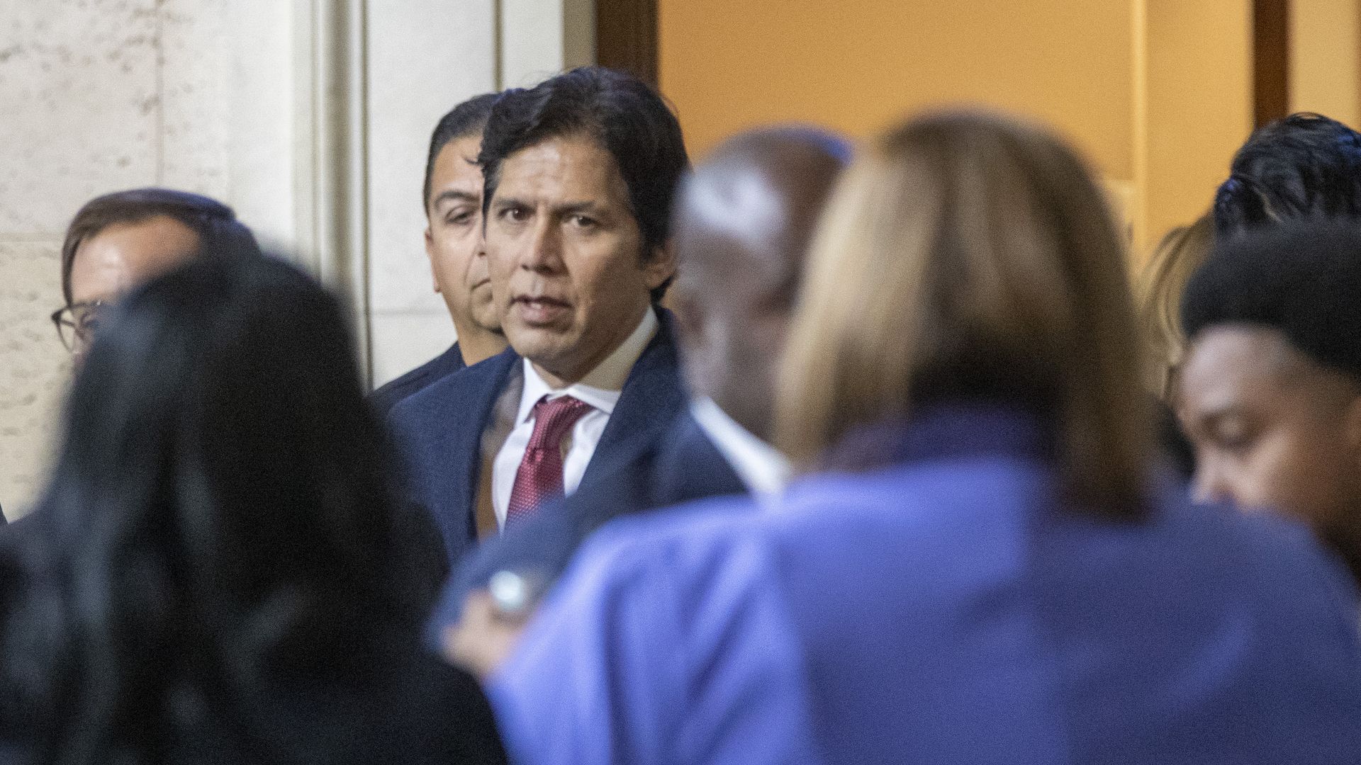 Photo of Kevin de León walking into a crowded chamber