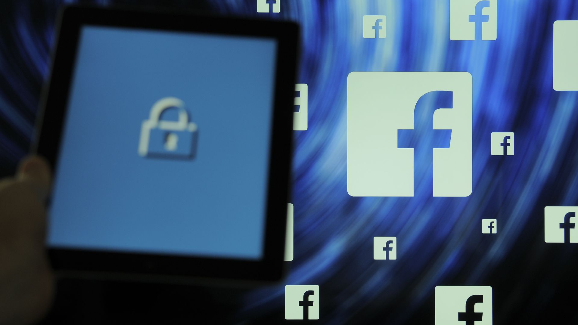Facebook logos surrounding a screen with a lock on it. 