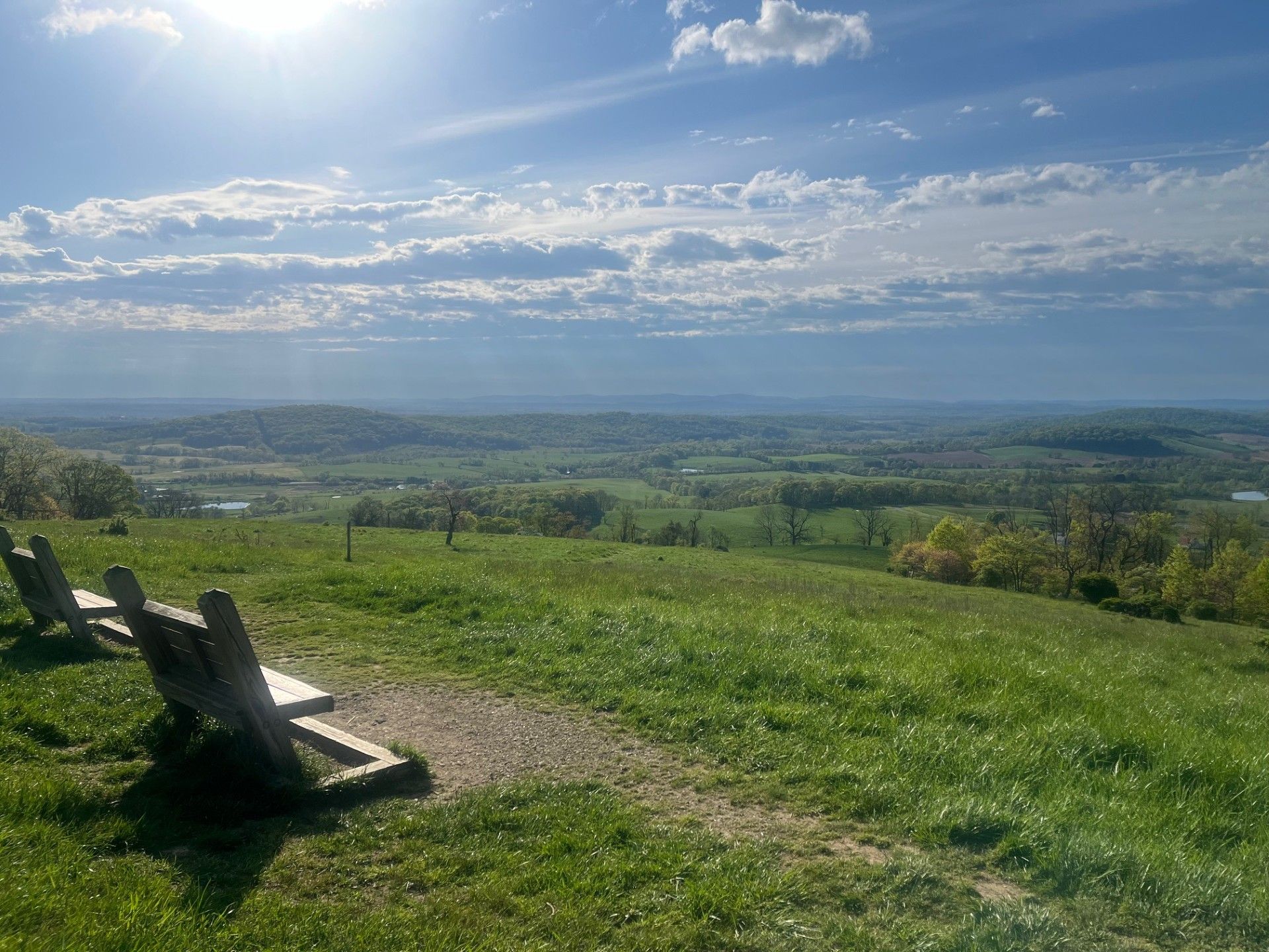 two chairs next to a view of greenery and a blue sky