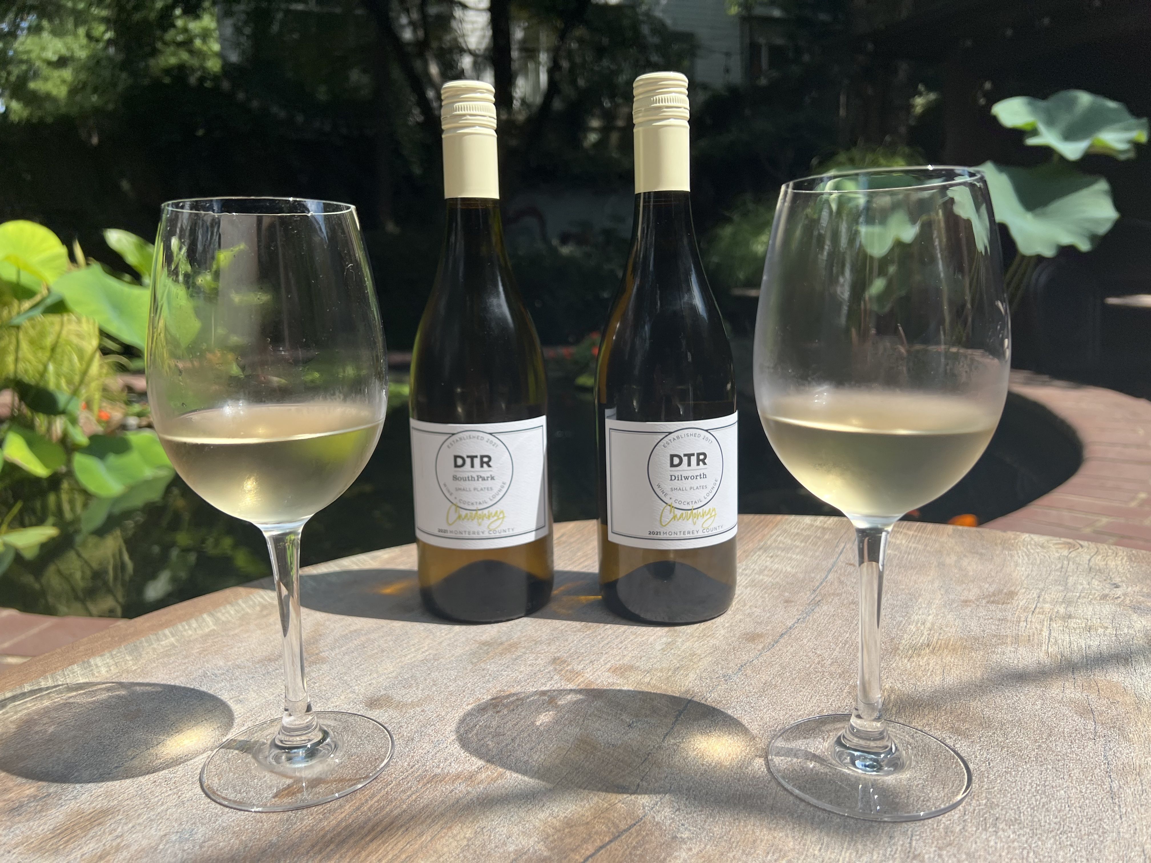 two glasses of wine and two bottles of wine on a table