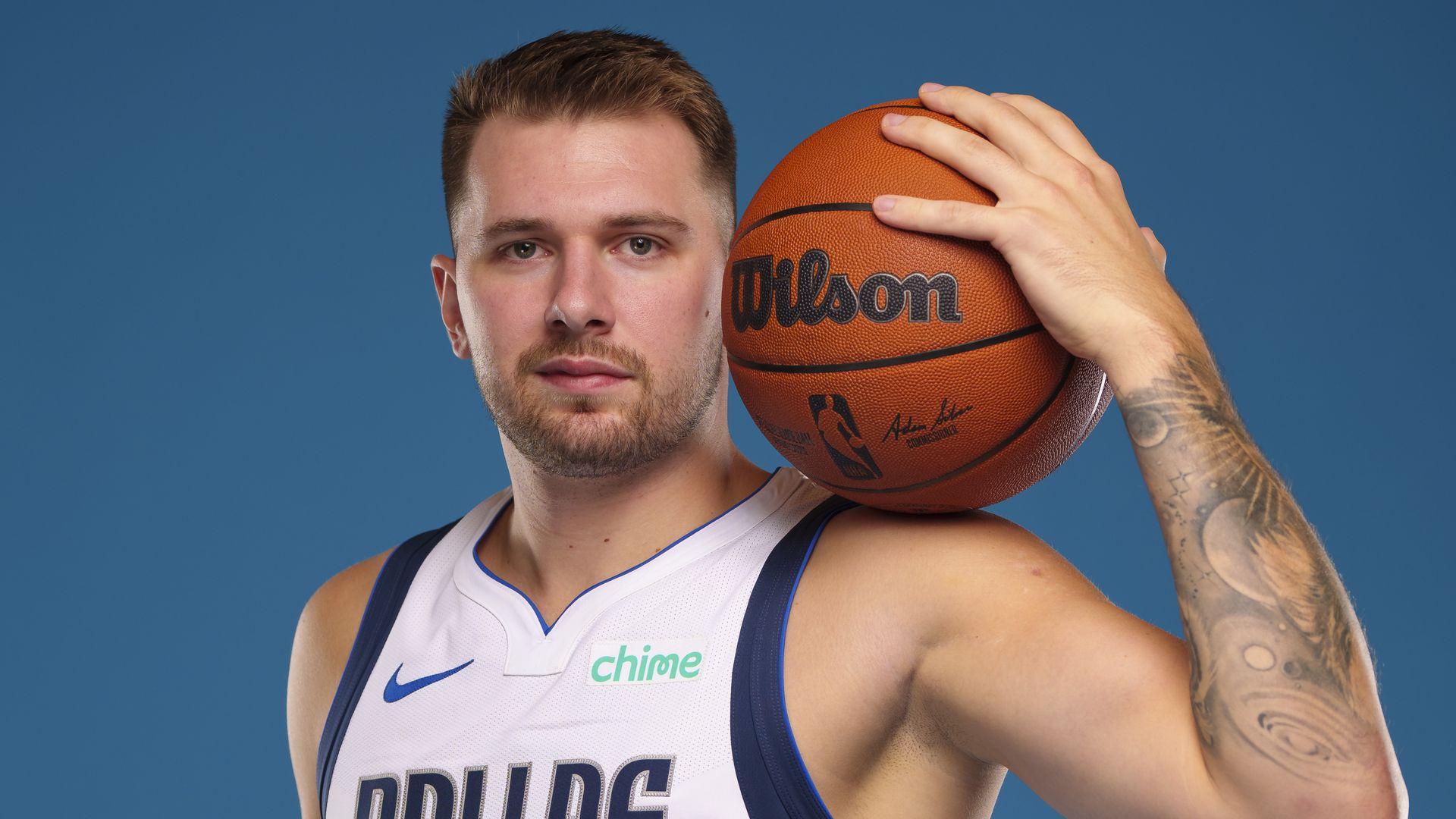 A basketball player poses with a basketball